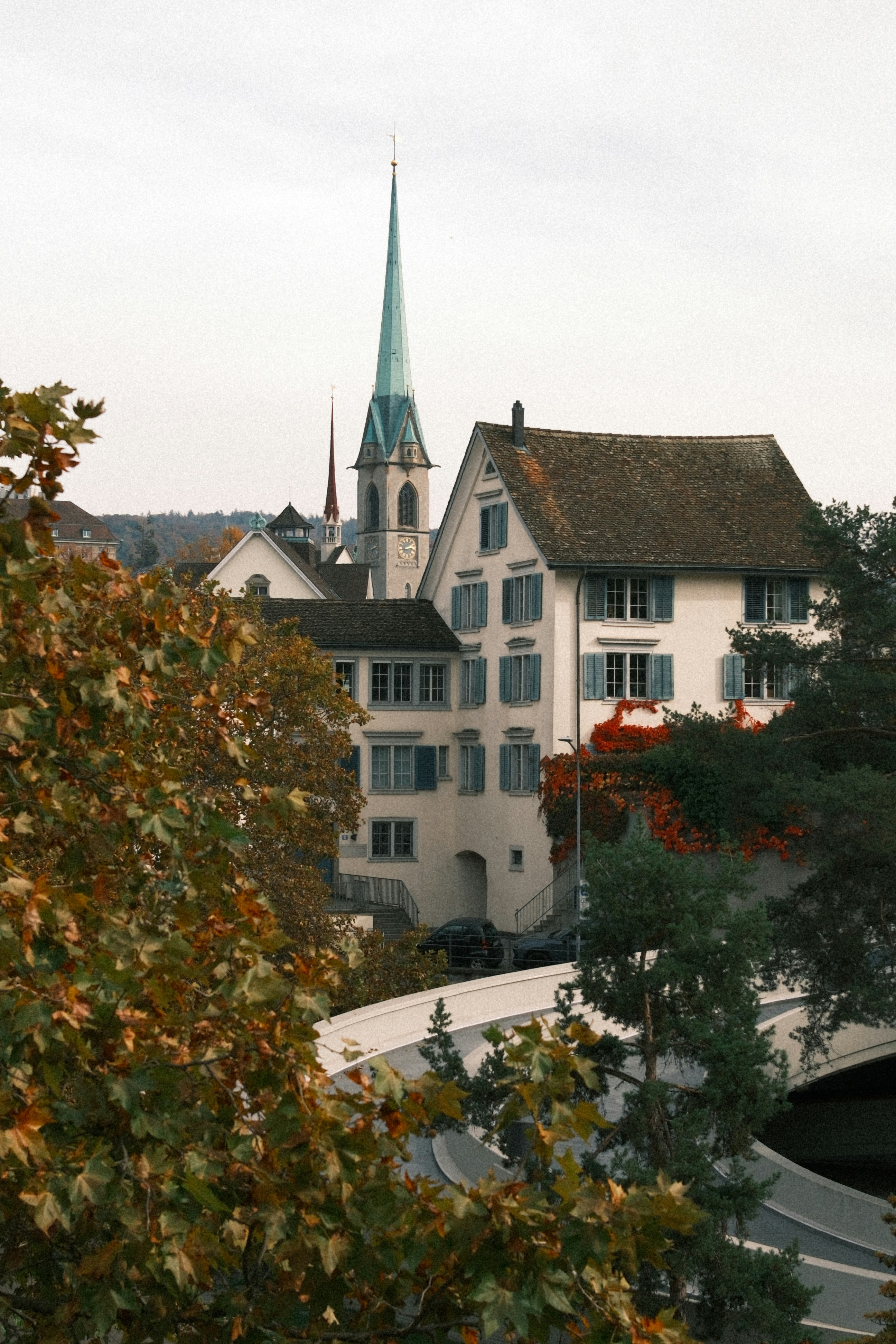 White building with blue shutters and tall spire.