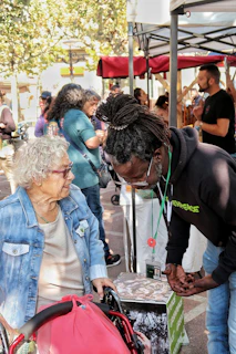 Elderly woman in wheelchair talks to man