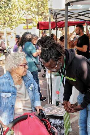 Elderly woman in wheelchair talks to man