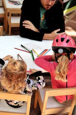 Children drawing at a table with an adult