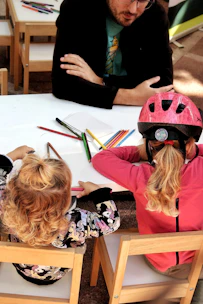 Children drawing at a table with an adult