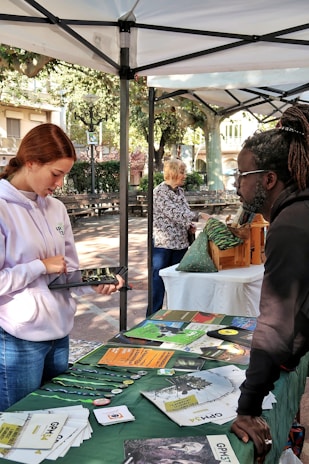 People at an outdoor information booth with displayed materials.