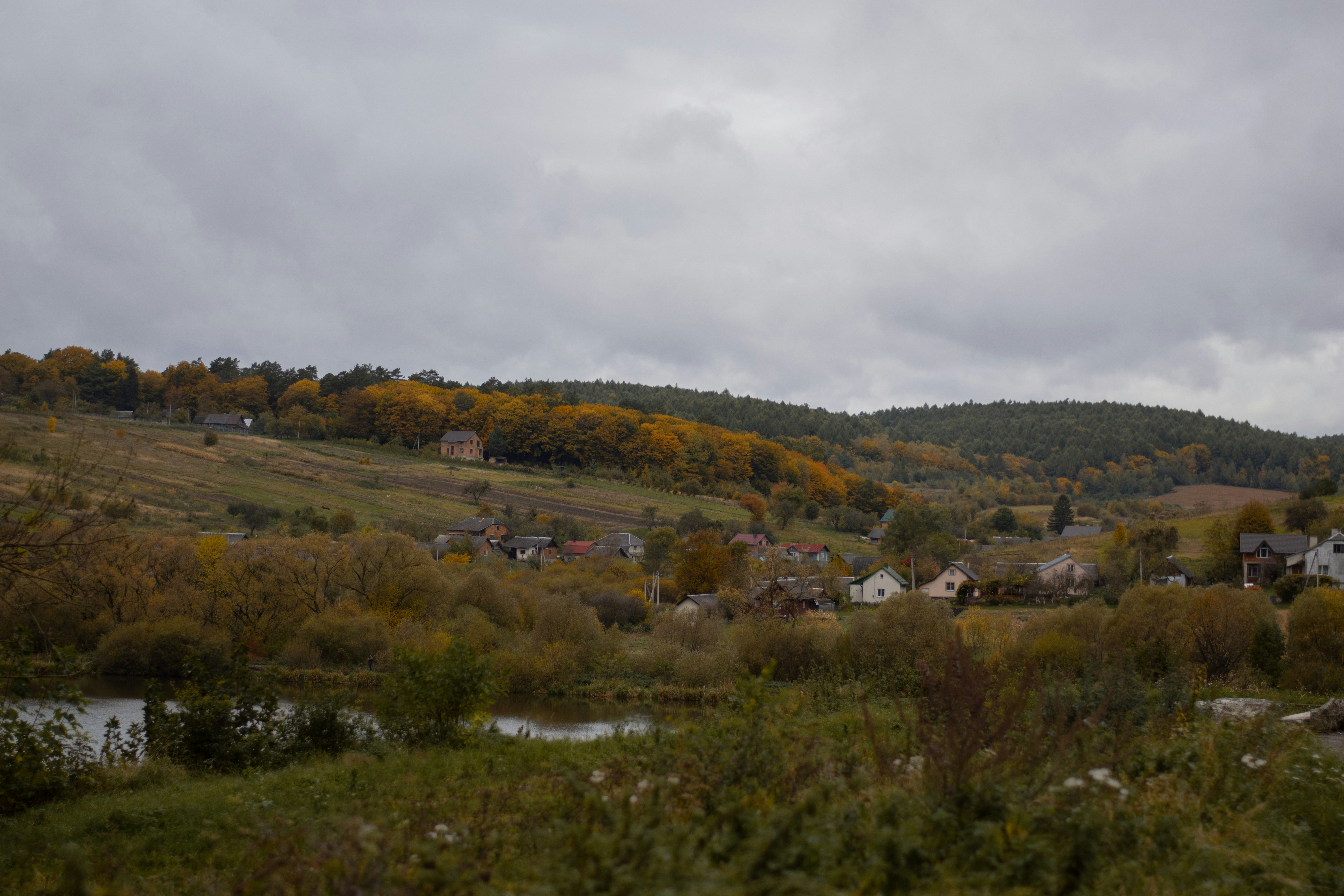 Autumn landscape with rolling hills and scattered village.