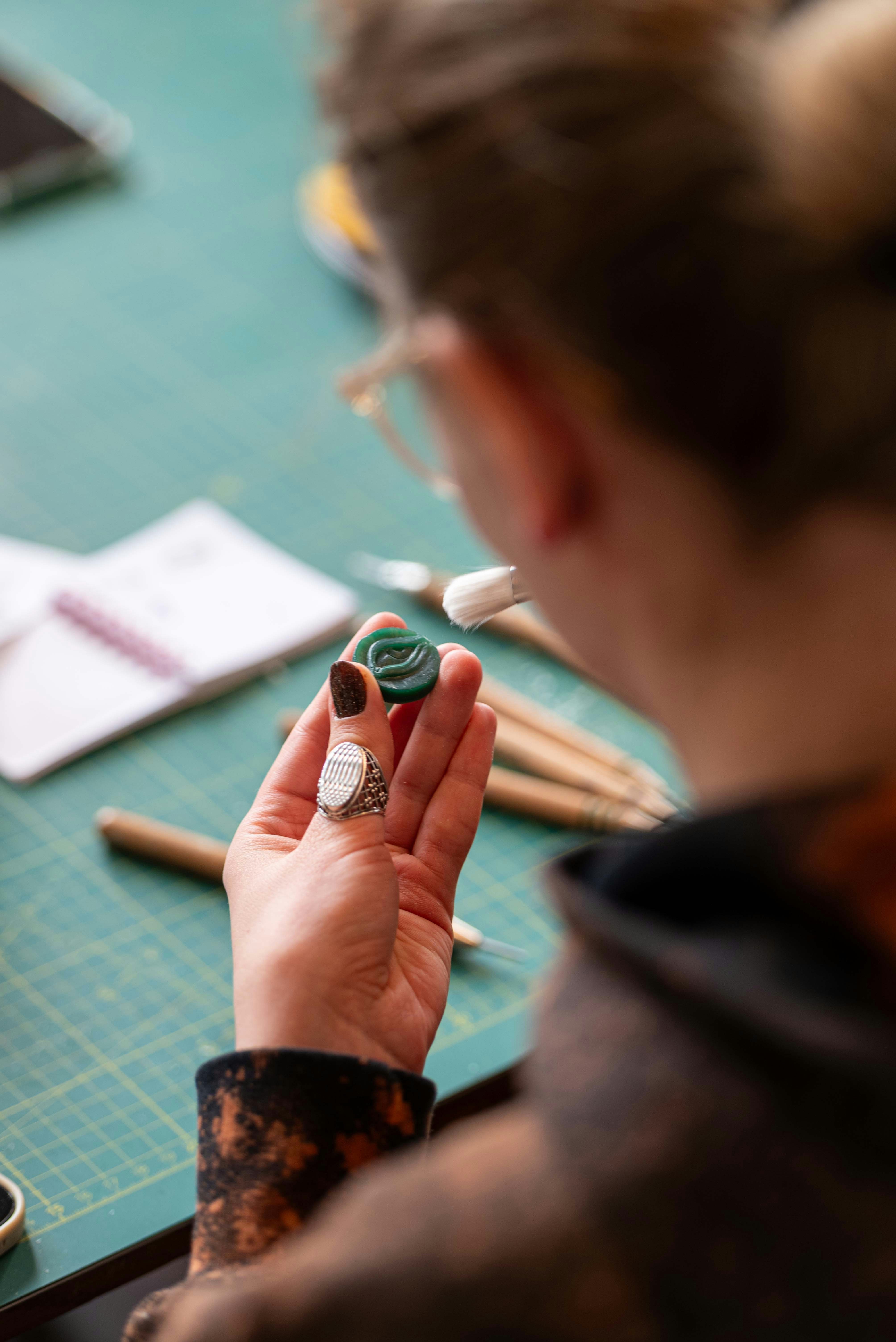 Person examining a green carved object