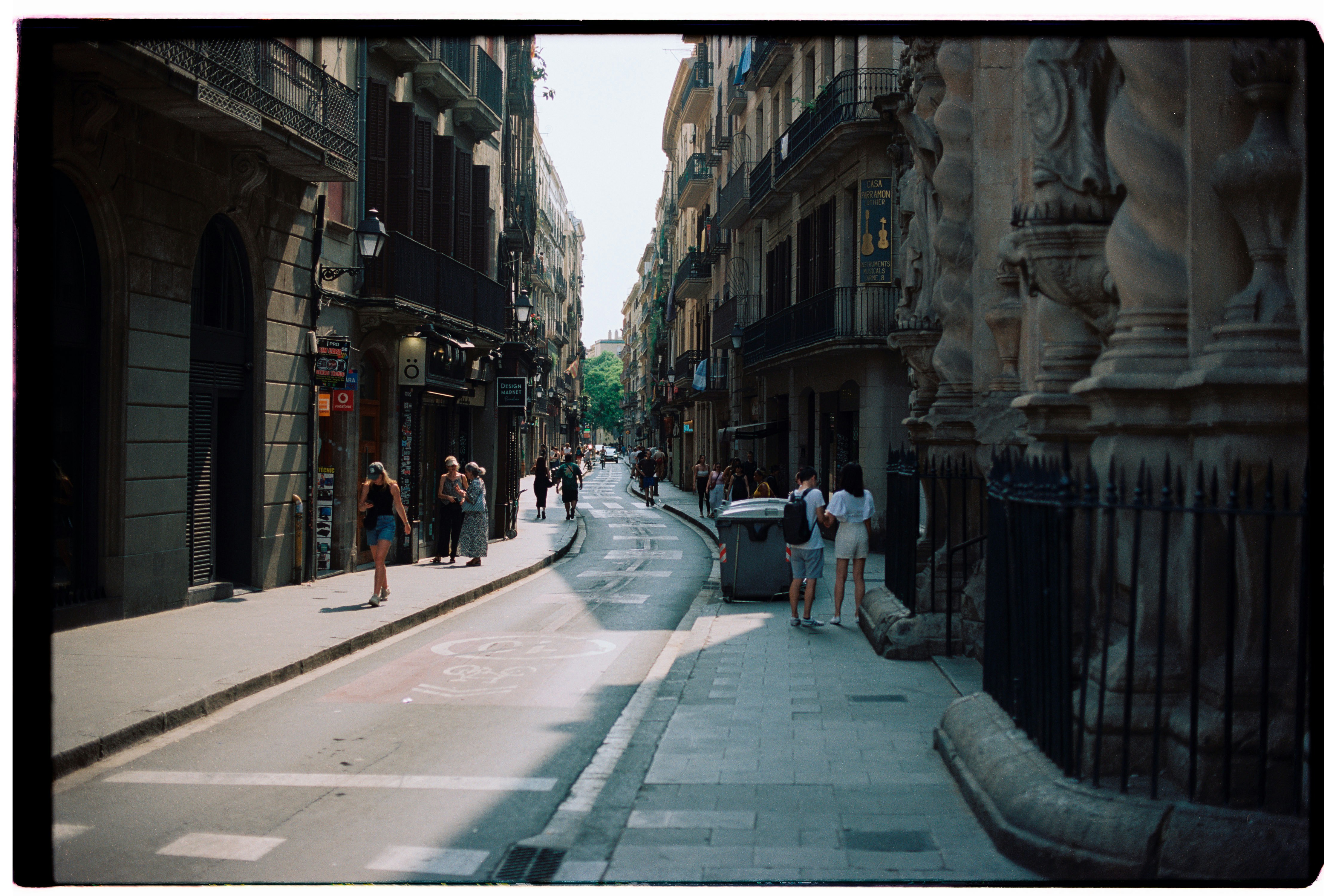 People walk down a narrow european street.