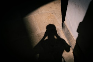 Shadow of a person holding head in dim light
