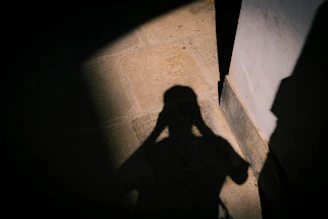 Shadow of a person holding head in dim light