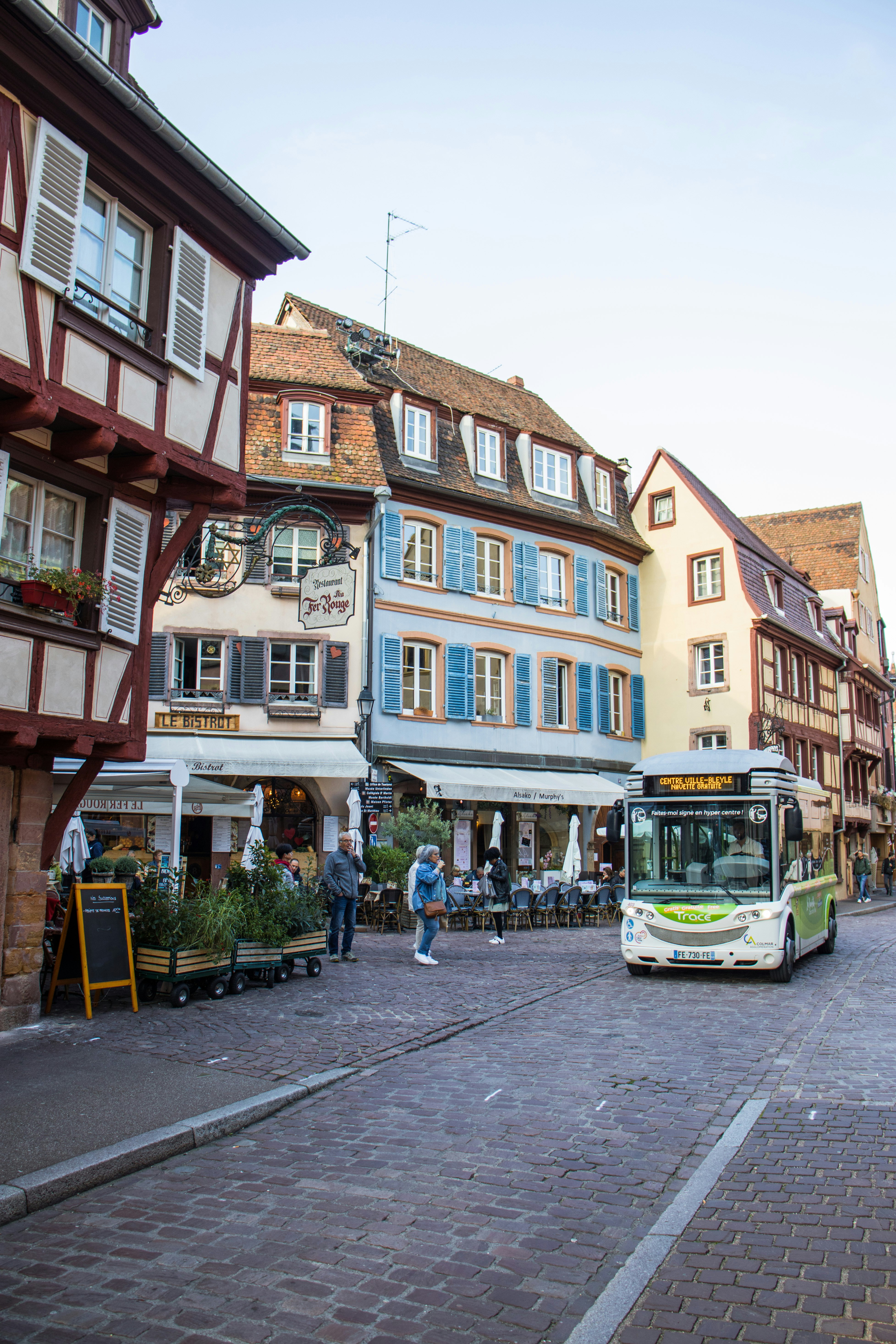 Autobús conduciendo por una calle empedrada en una ciudad europea.