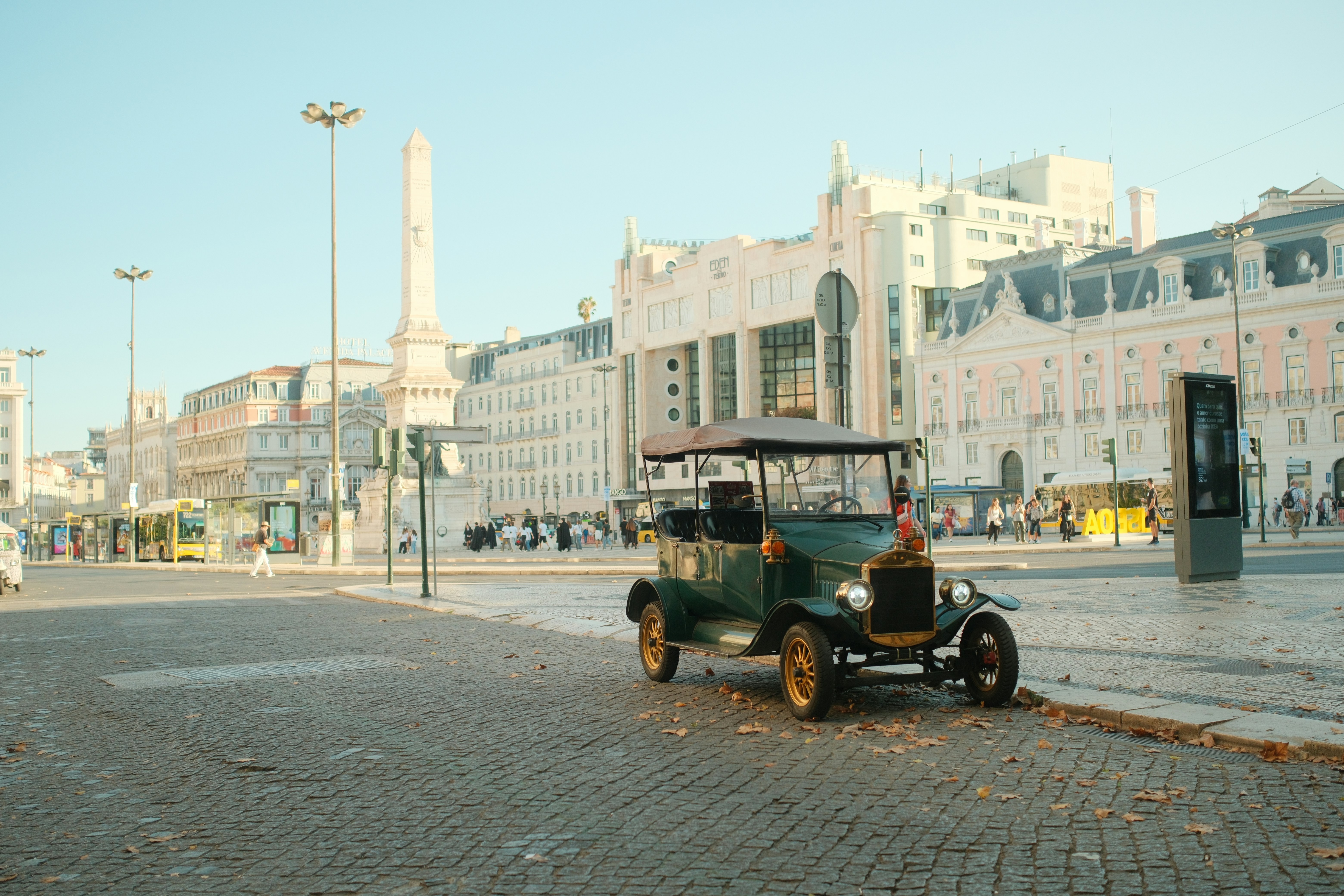 Voiture ancienne garée sur une rue pavée typique de Lisbonne sous un soleil printanier éclatant