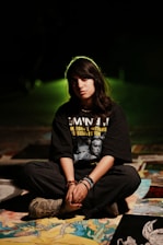 Young woman sitting cross-legged with artwork