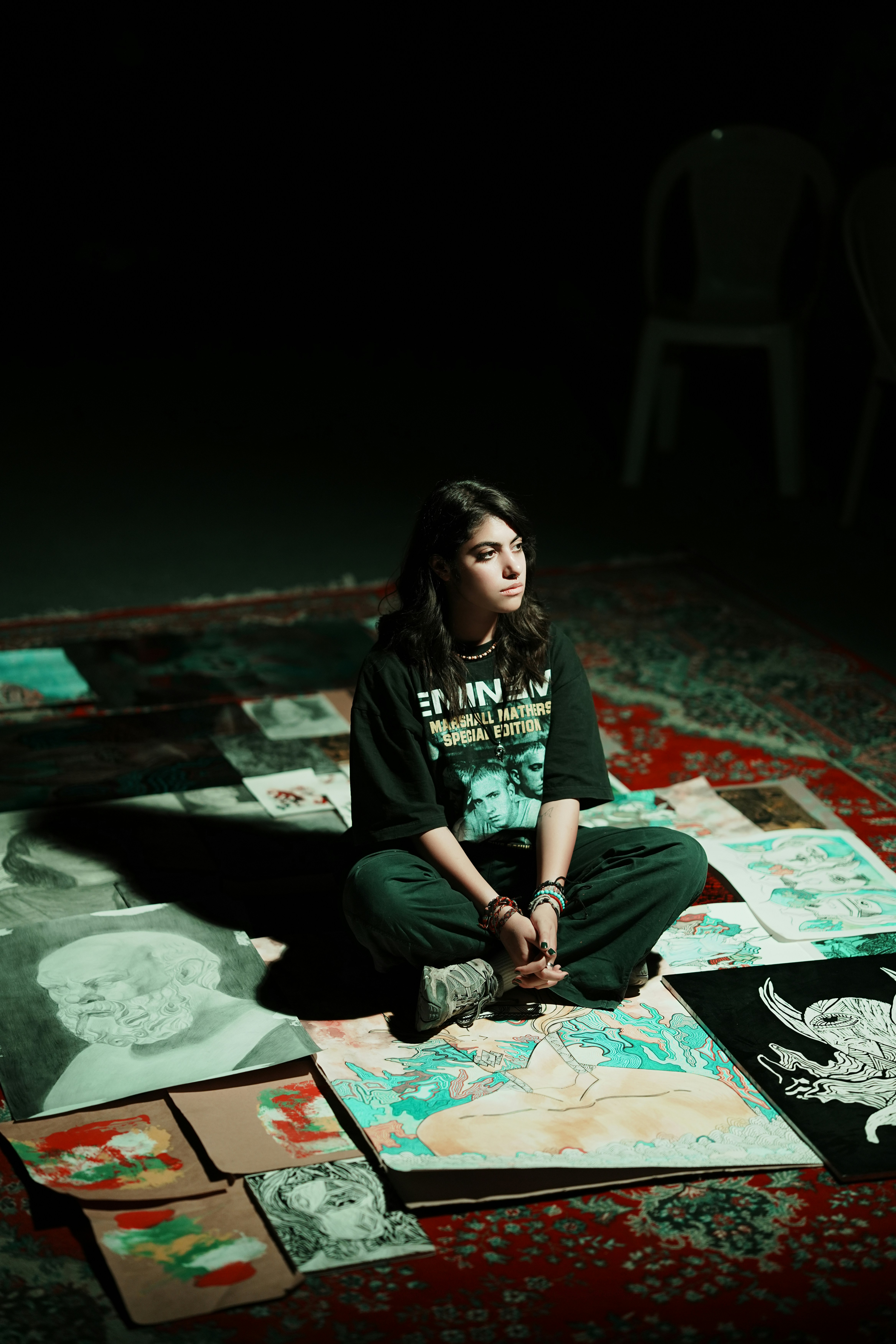 Young woman sitting amidst art on a rug