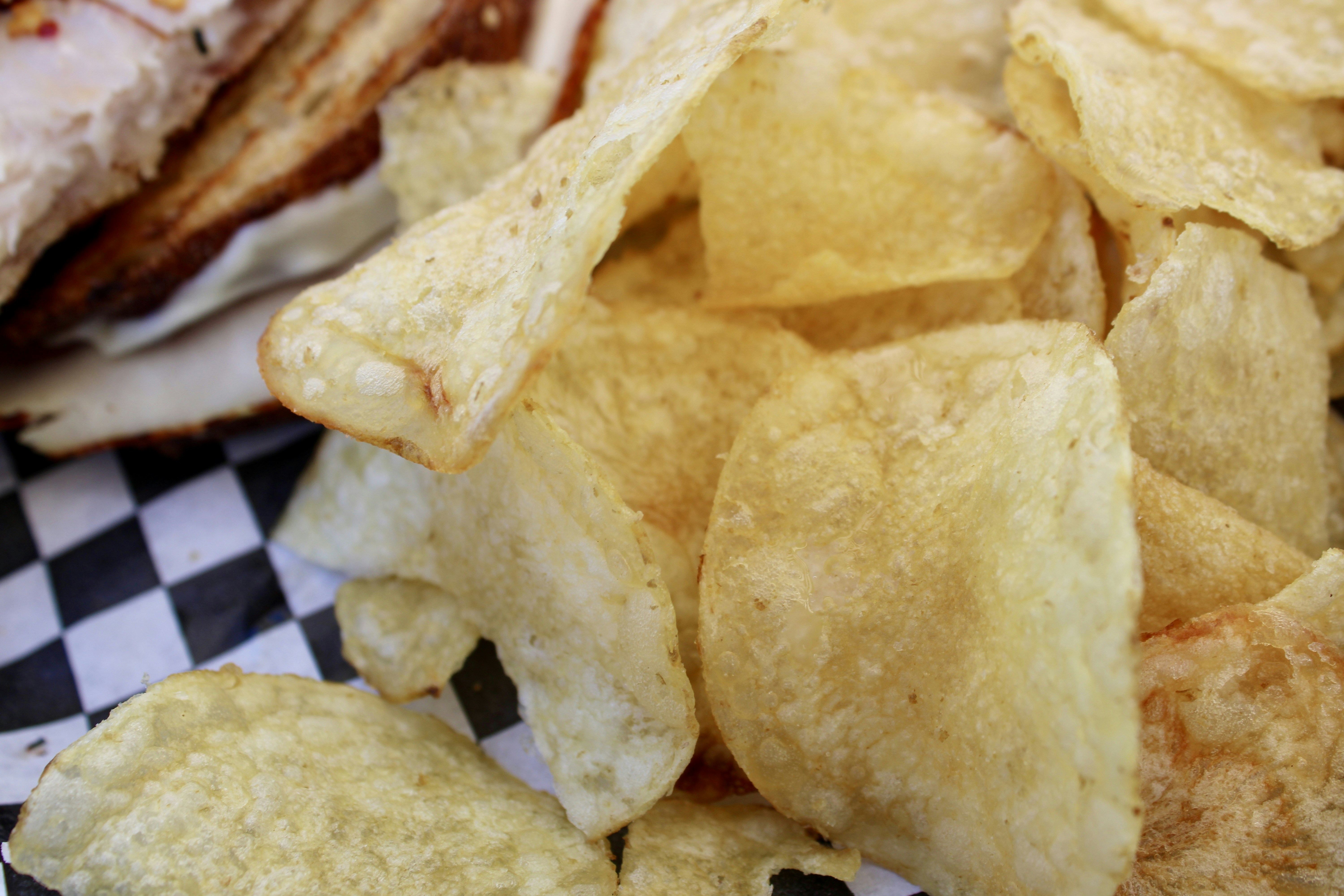 Crispy potato chips piled on checkered paper