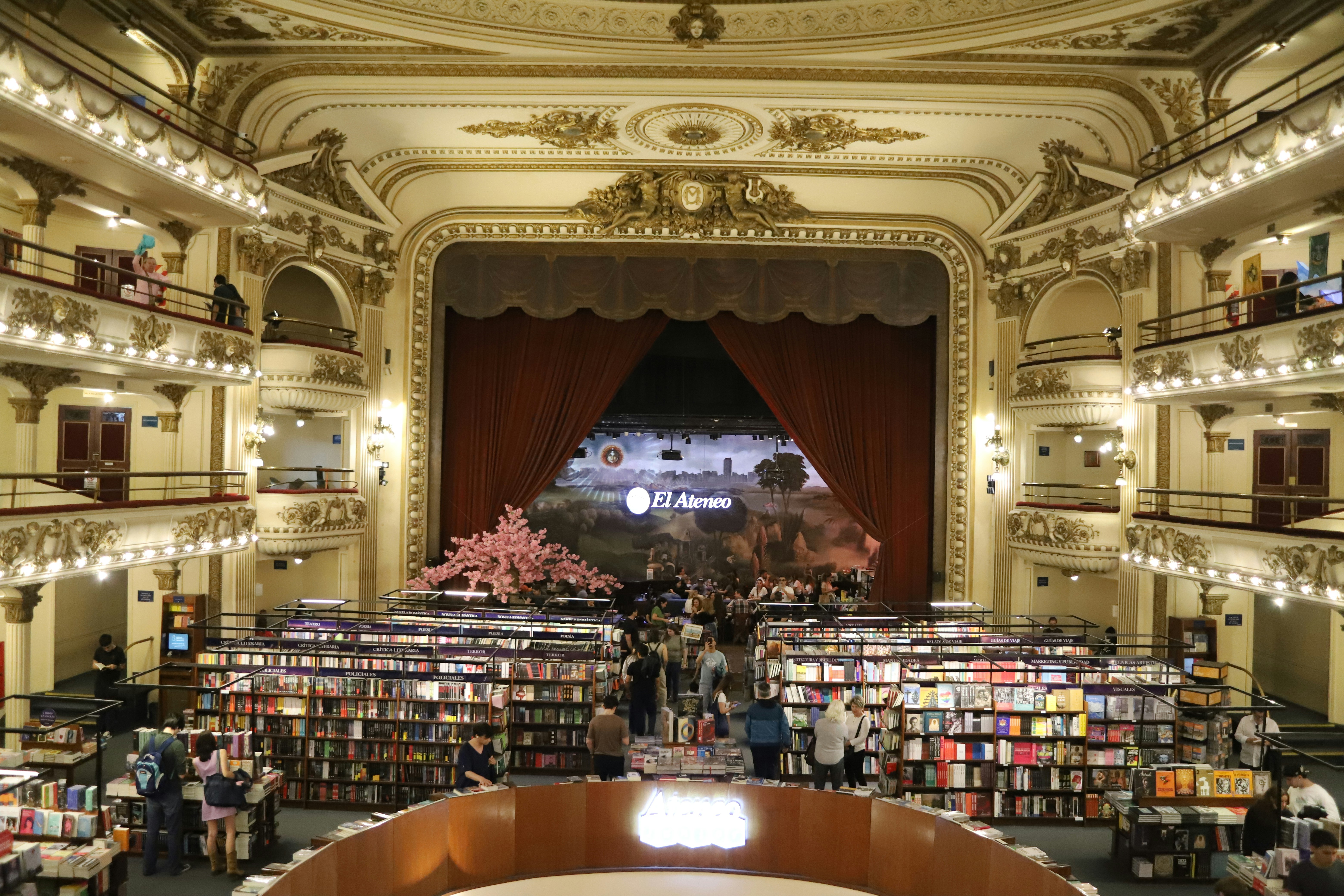 Grand theater interior with bookshelves and stage.