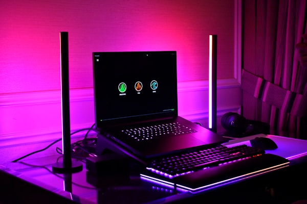 Gaming setup with laptop, keyboard, and rgb lighting.
