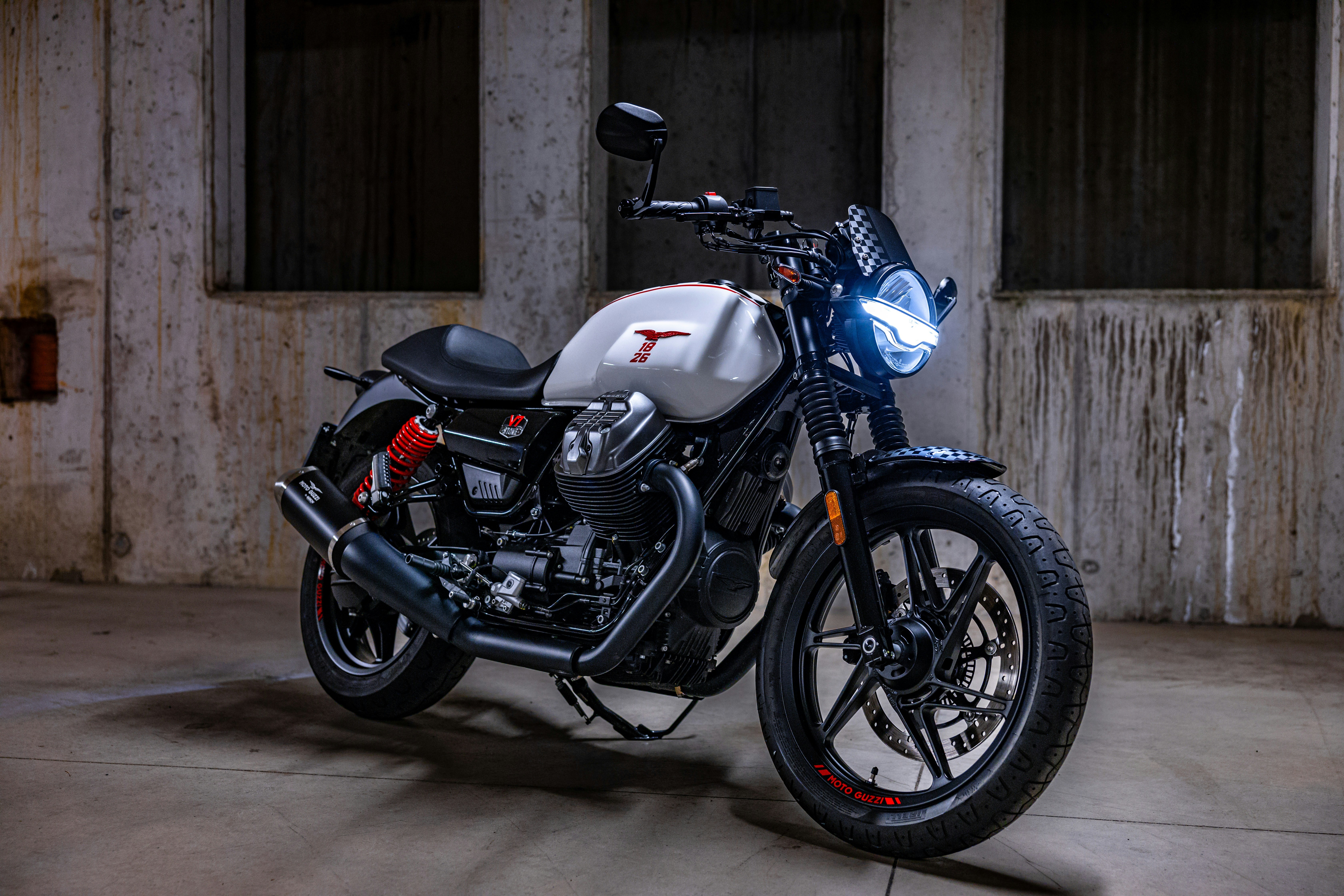 Une moto blanche moderne garée à l’intérieur.