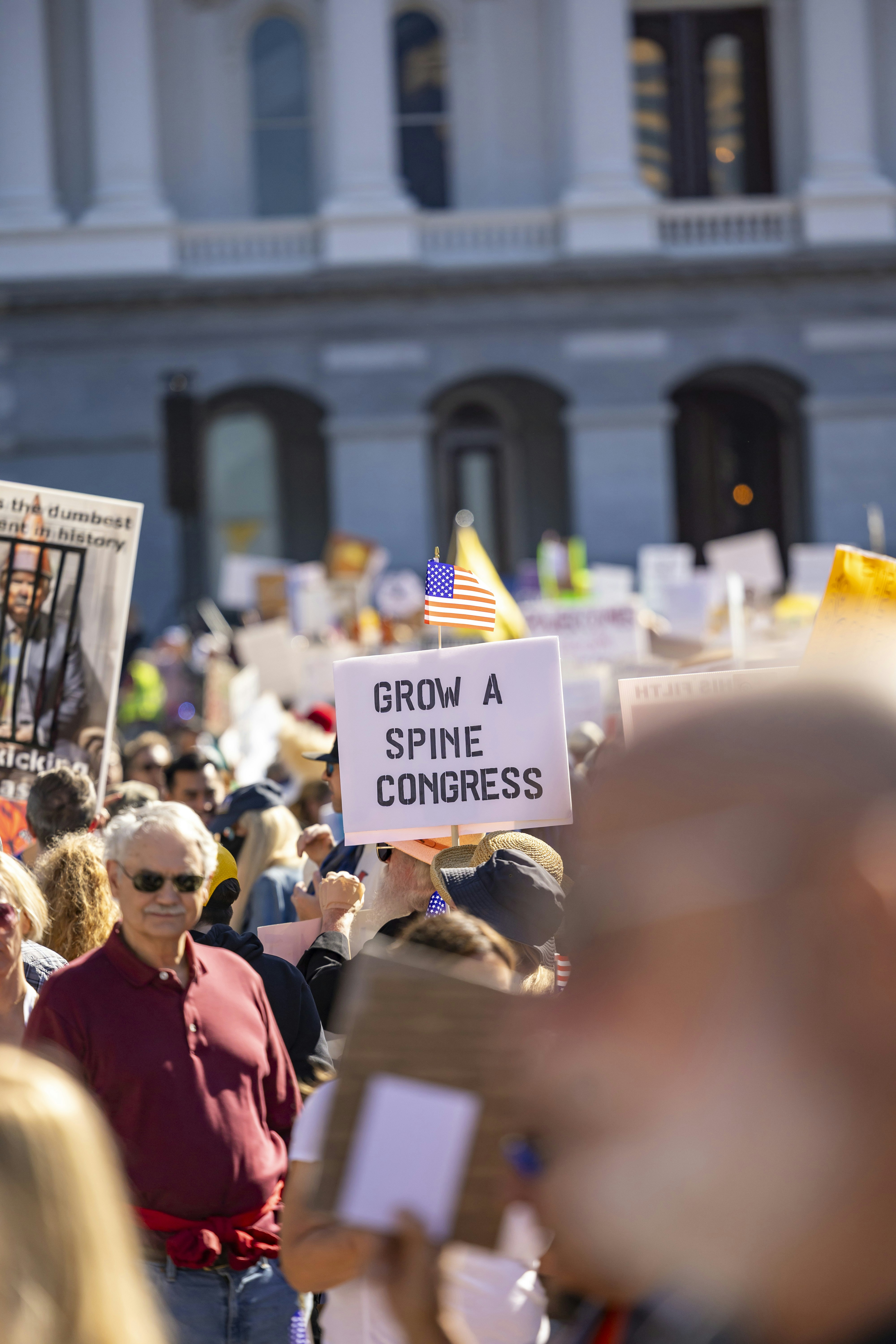 Manifestantes sostienen carteles frente a un edificio gubernamental.