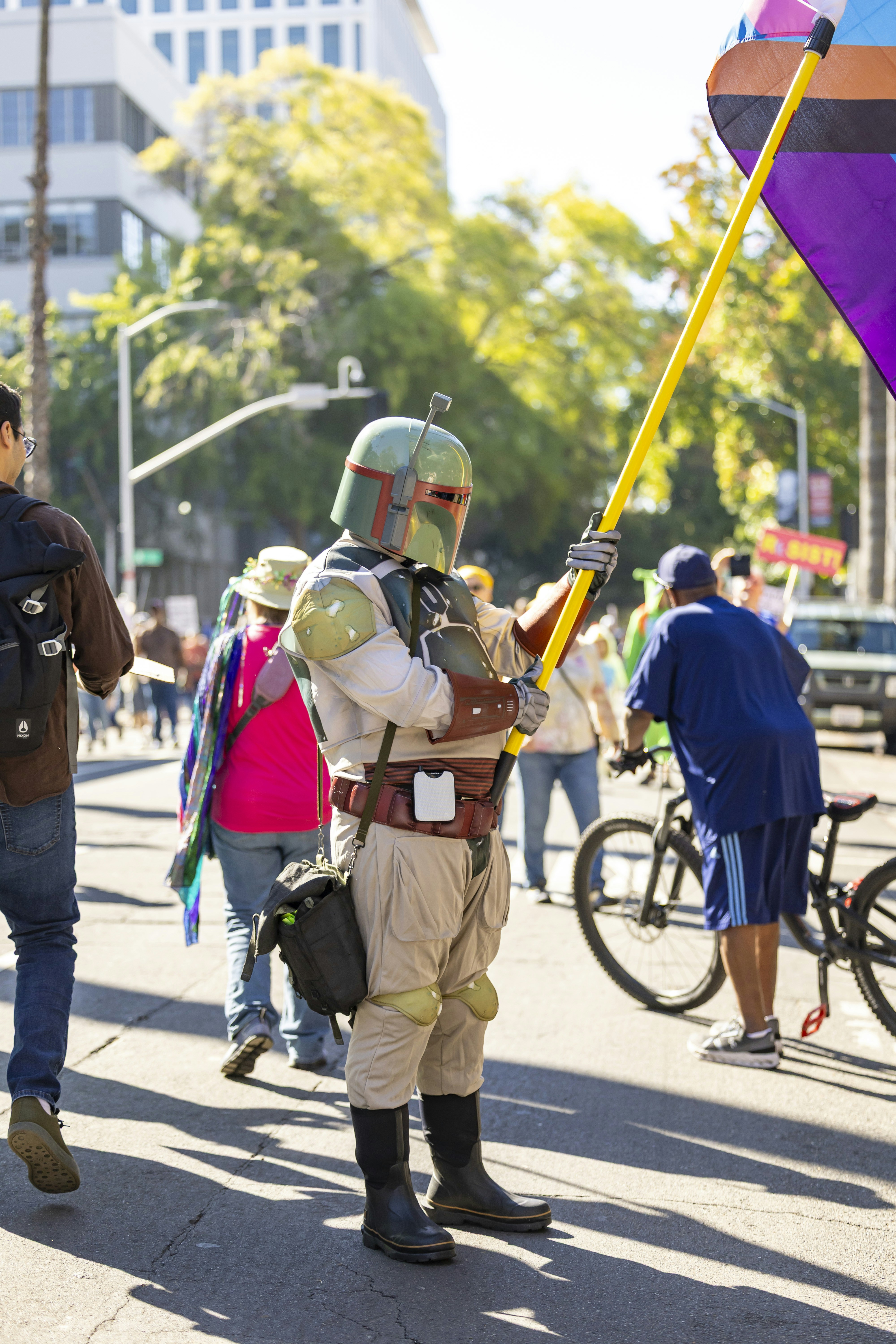 Orang dengan kostum boba fett memegang tiang kuning