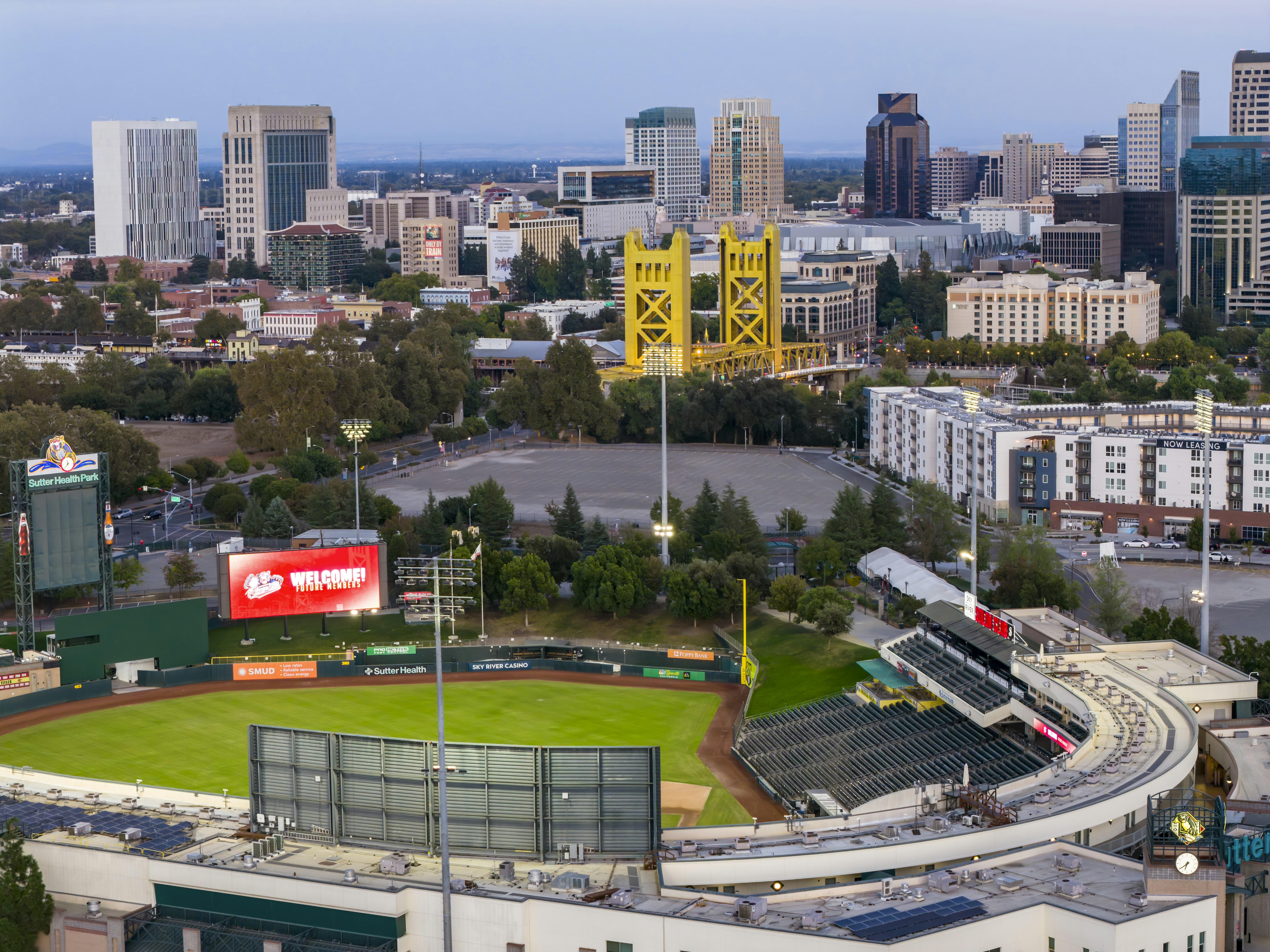 Cityscape with baseball stadium and yellow bridge.