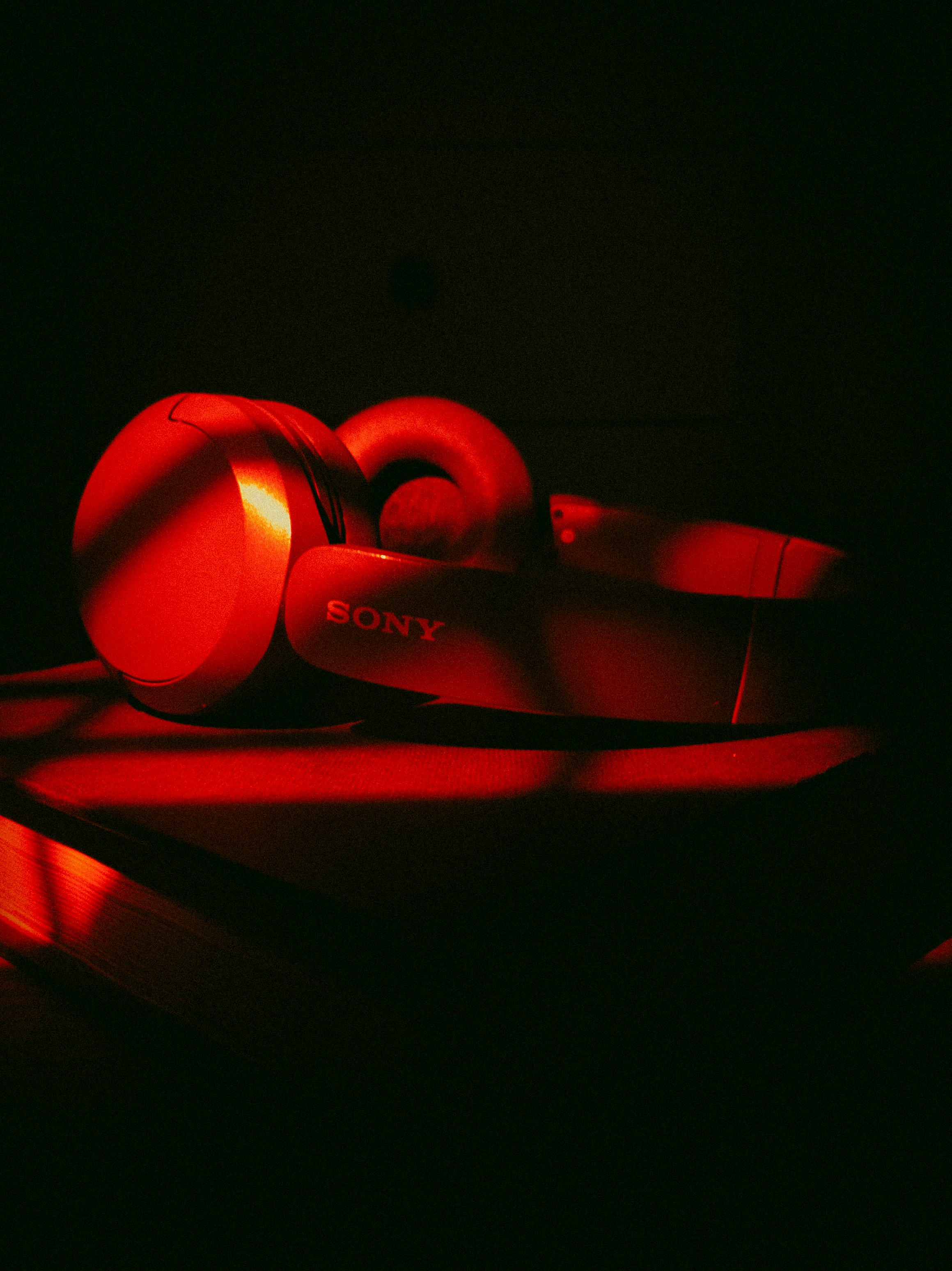 Red sony headphones on a dark surface