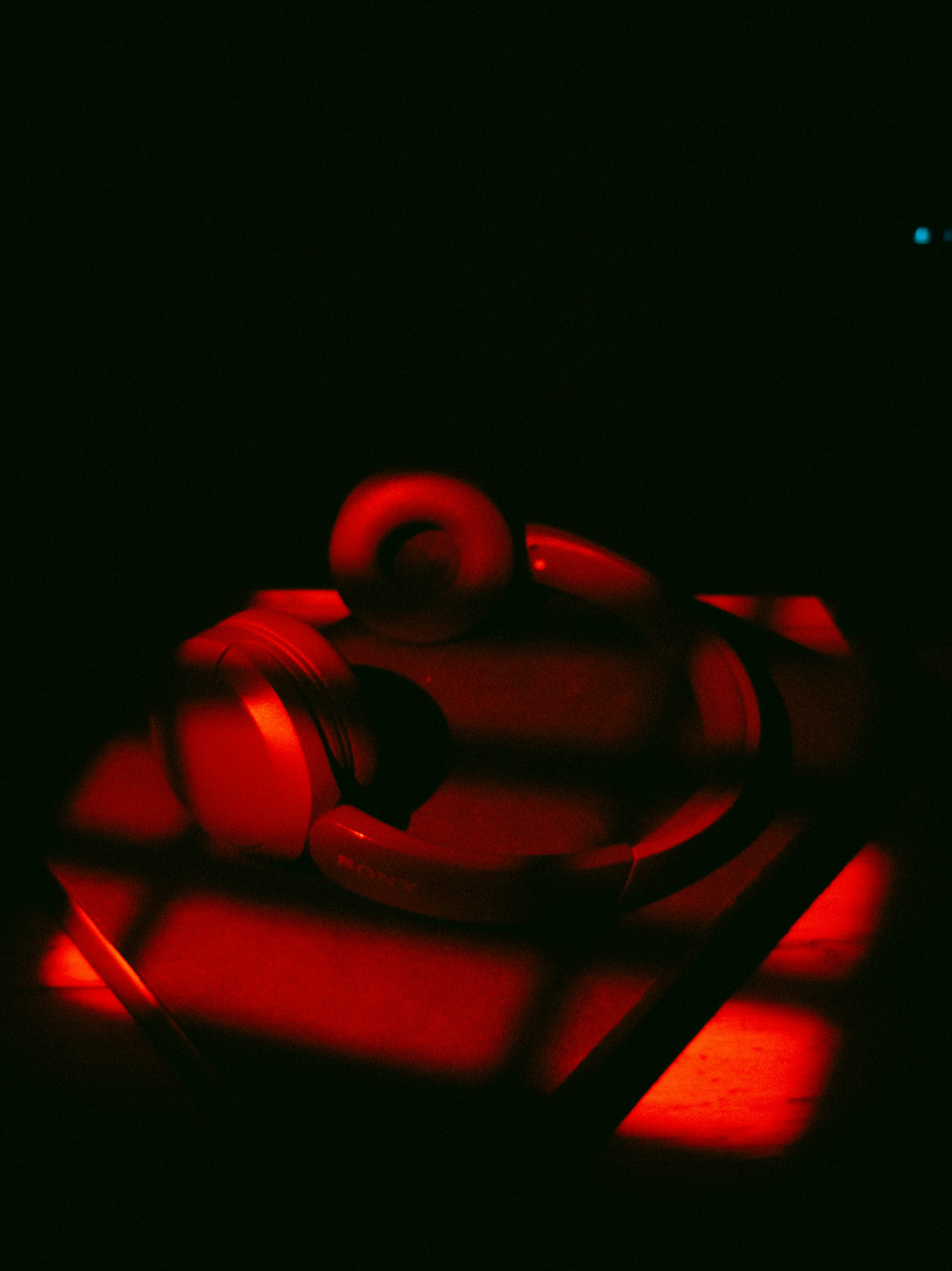 Red headphones on a dark surface with light patterns.