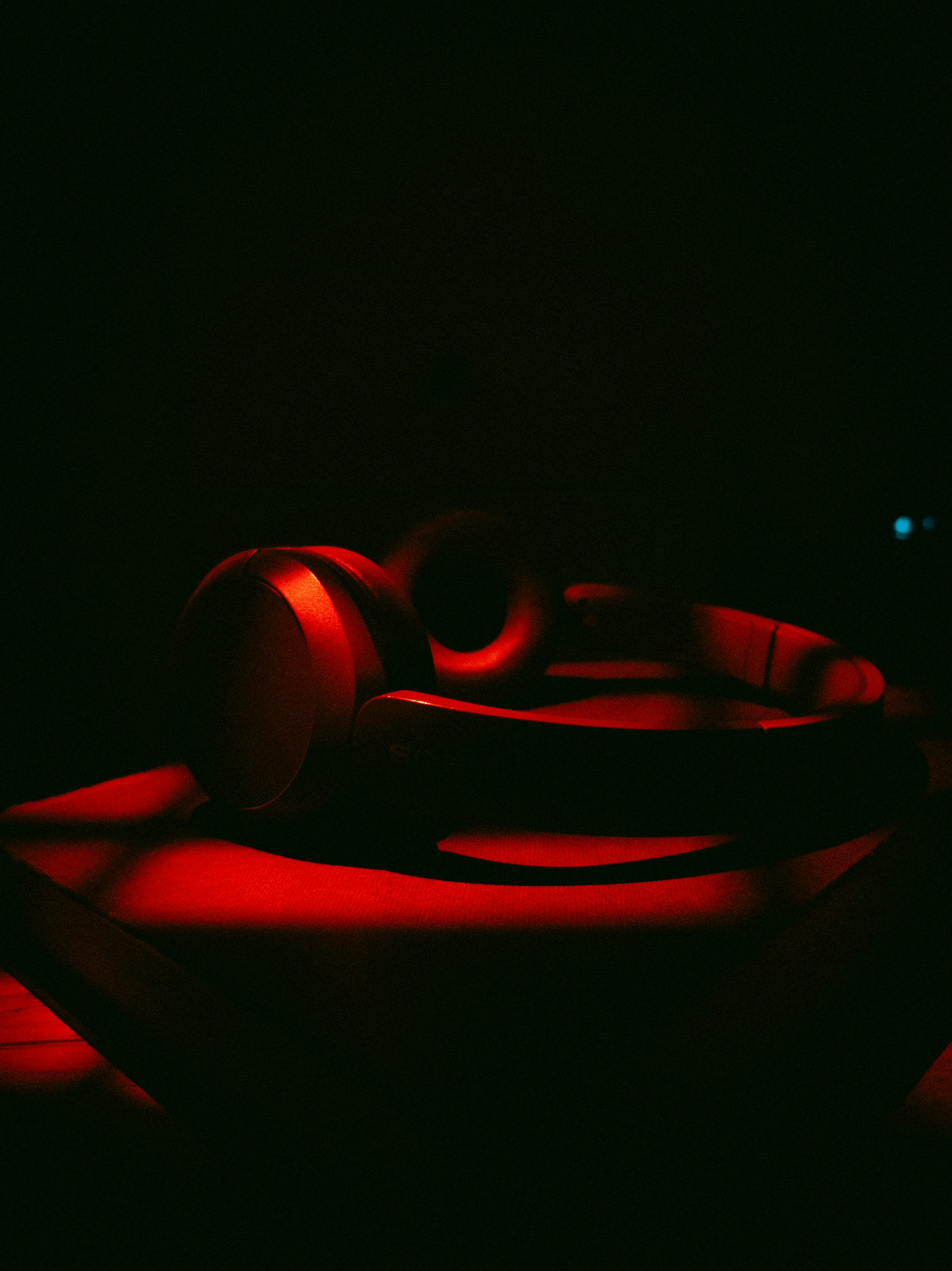 Red illuminated headphones resting on a dark surface