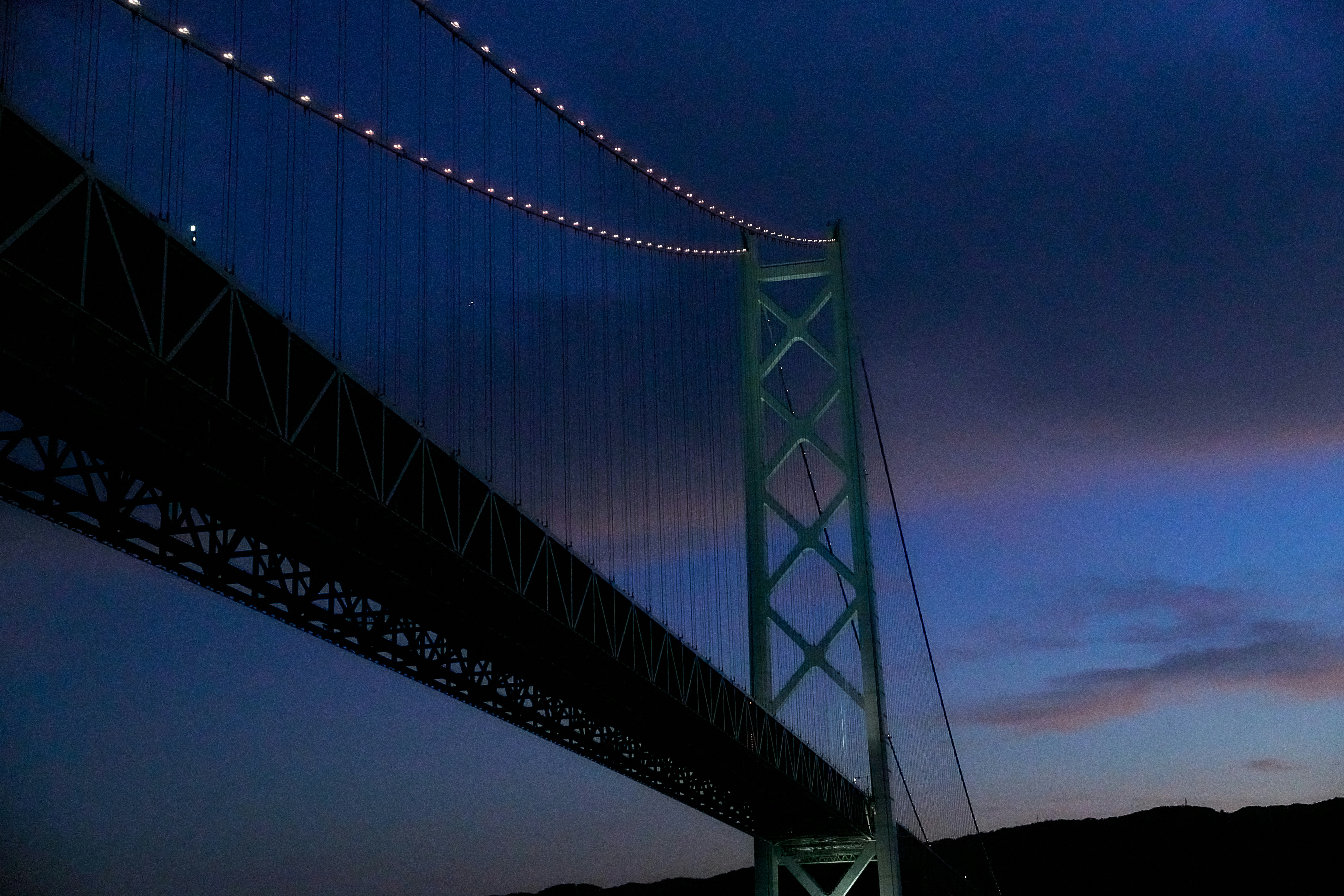Illuminated suspension bridge against a twilight sky