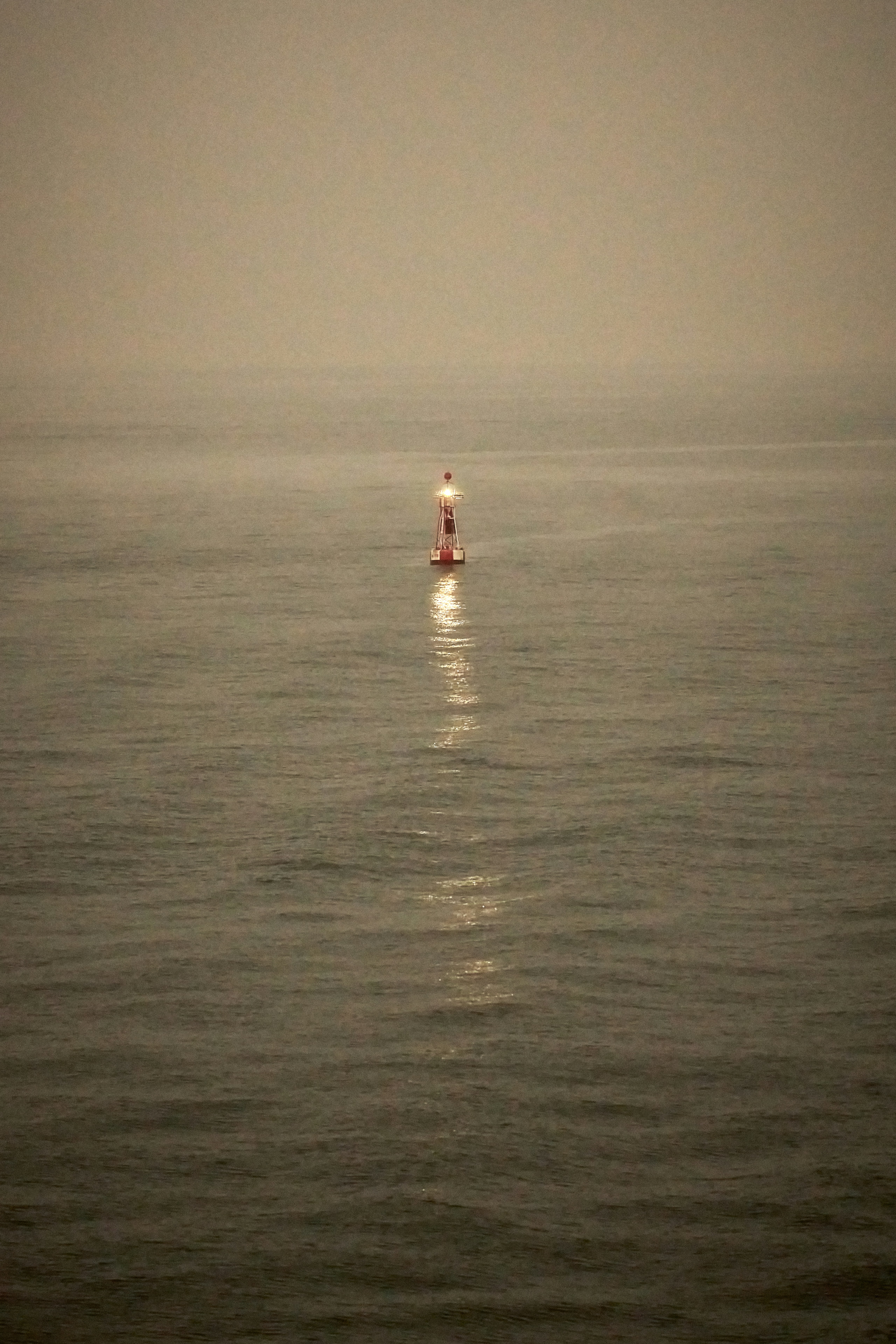 Lighthouse standing alone in the foggy sea