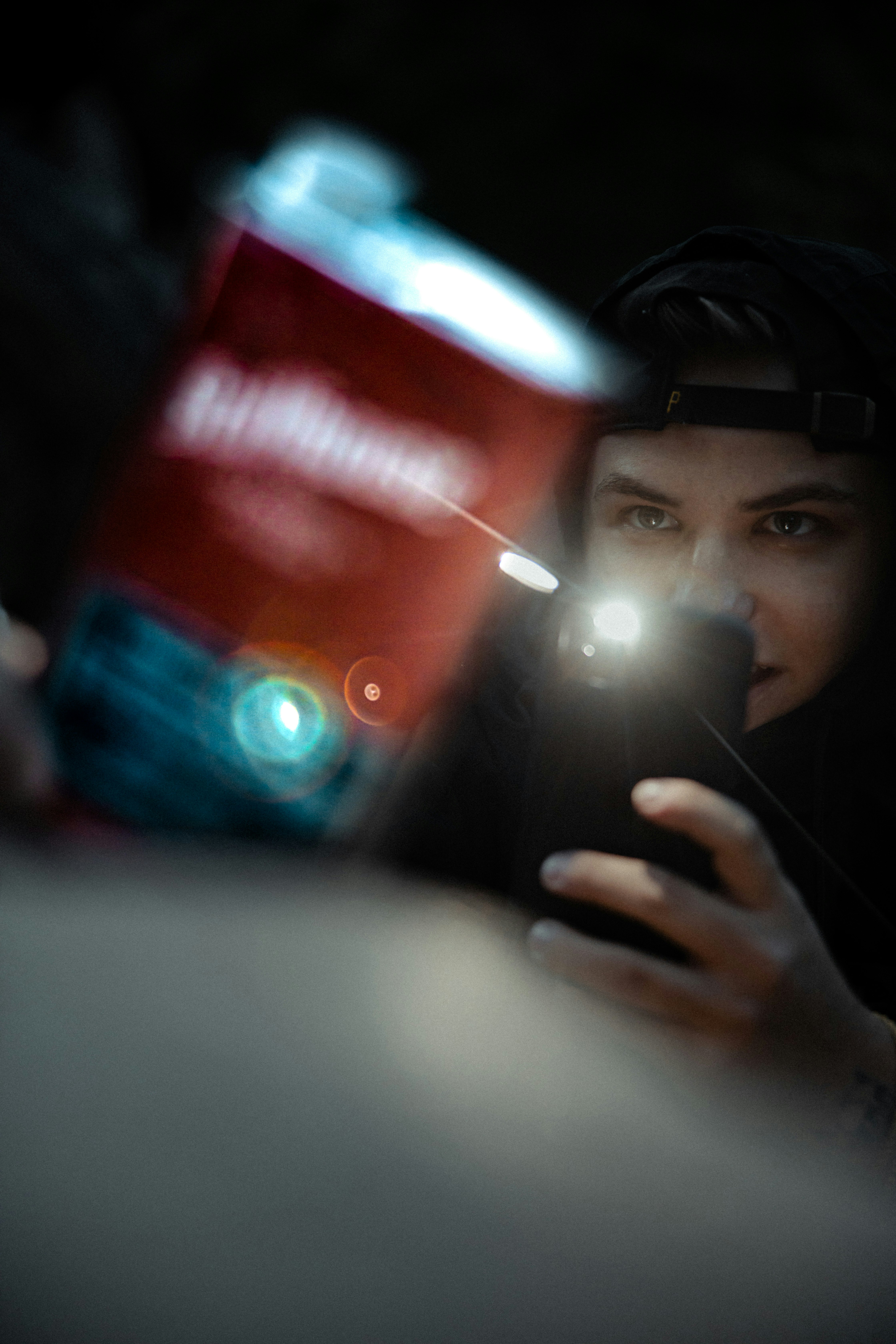 Person holding a red can and a phone