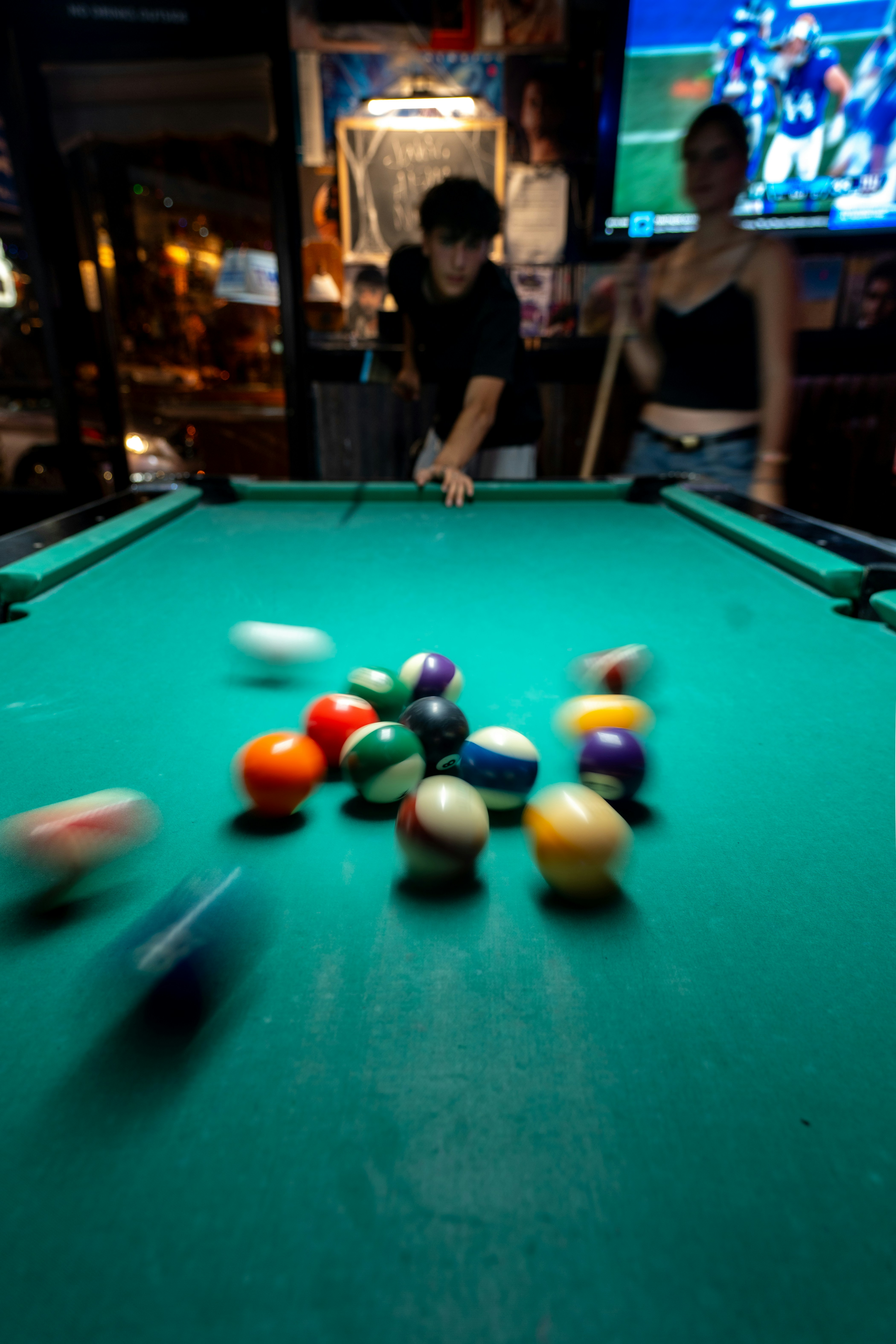 Gente jugando al billar con pelotas en movimiento