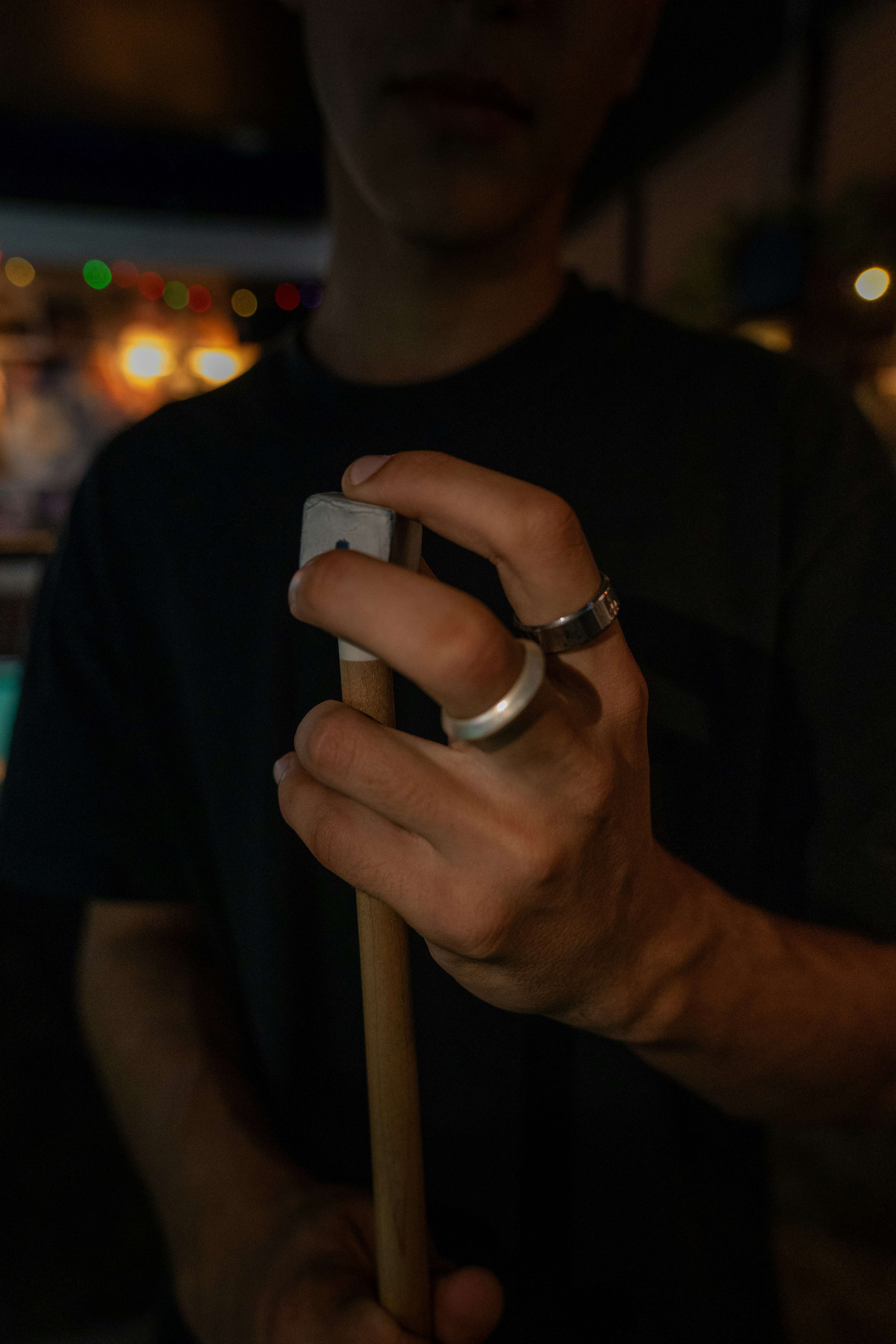 Persona sosteniendo un taco de billar con anillos