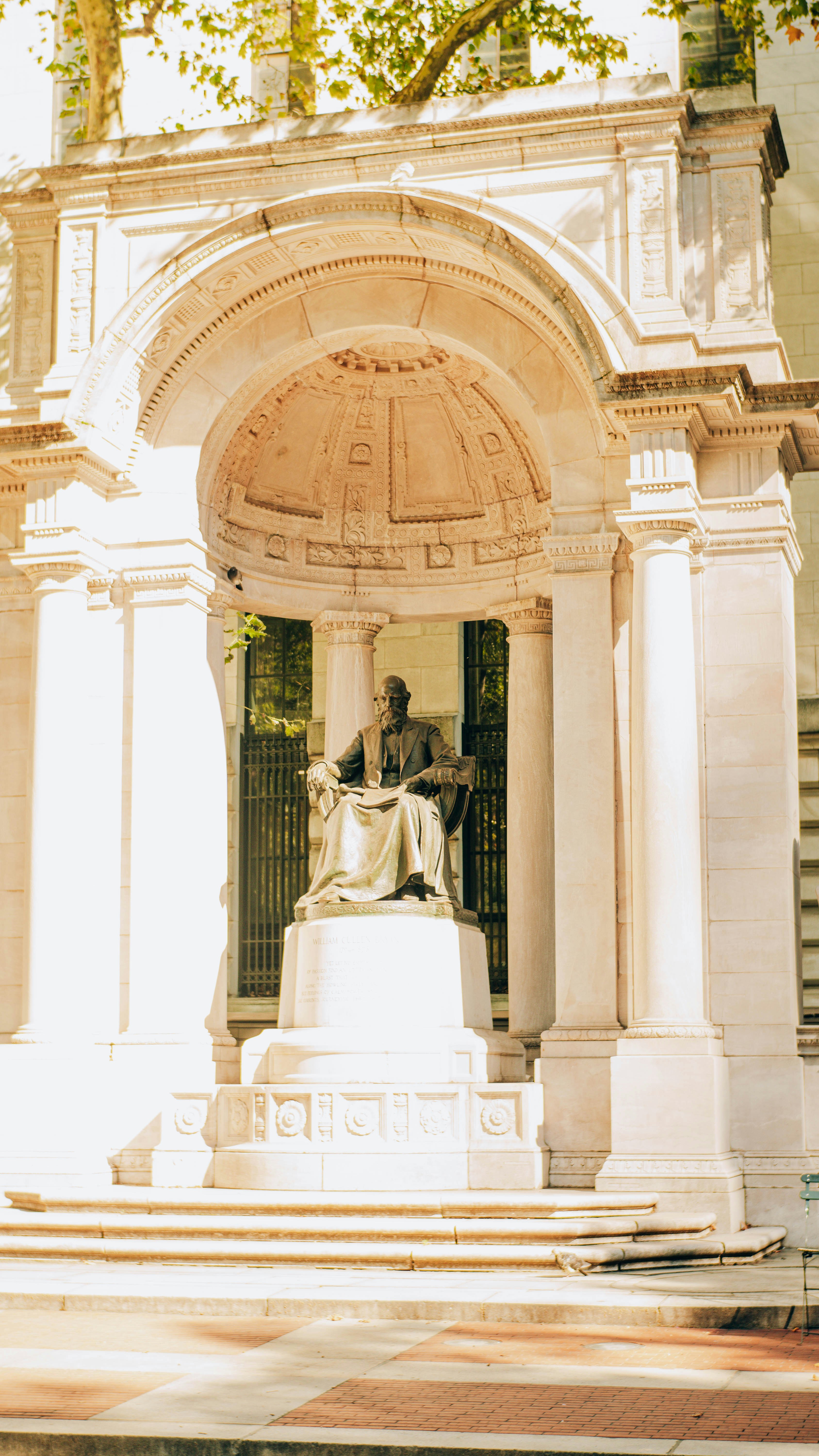 A statue sits under an ornate stone archway.