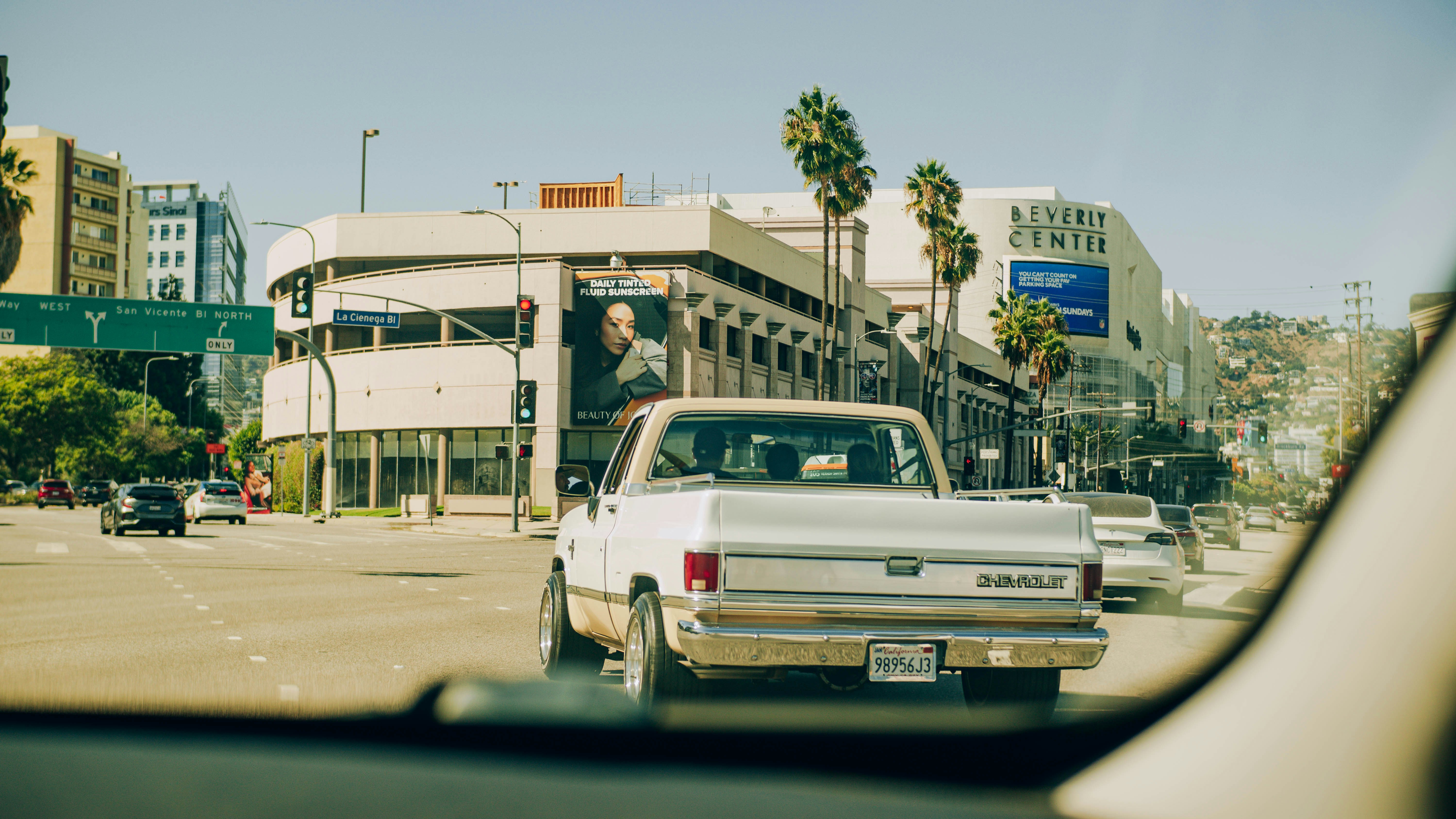 White pickup truck driving on a city street.