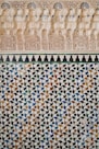Intricate tilework and carved plaster details on a wall.