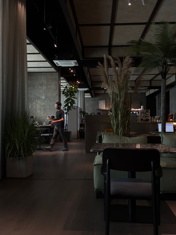 Modern cafe interior with plants and seating areas