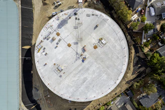 Large circular structure under construction with cranes.