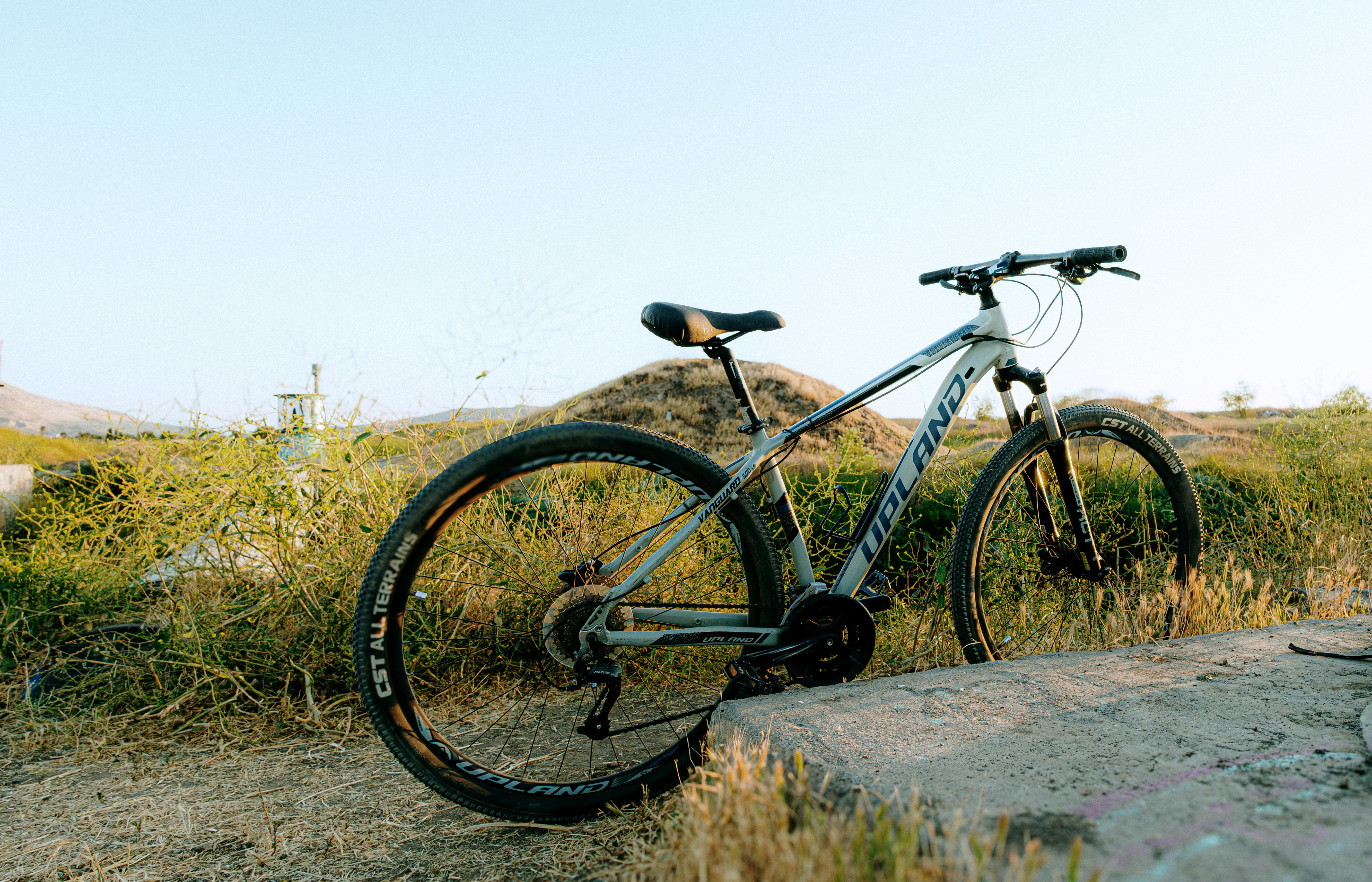 A bicycle rests on a concrete ledge outdoors.