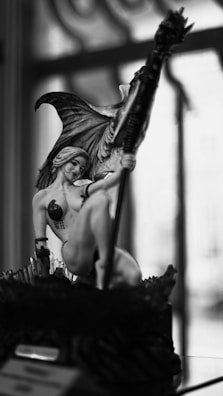 A fantasy statue of a winged woman and a creature.