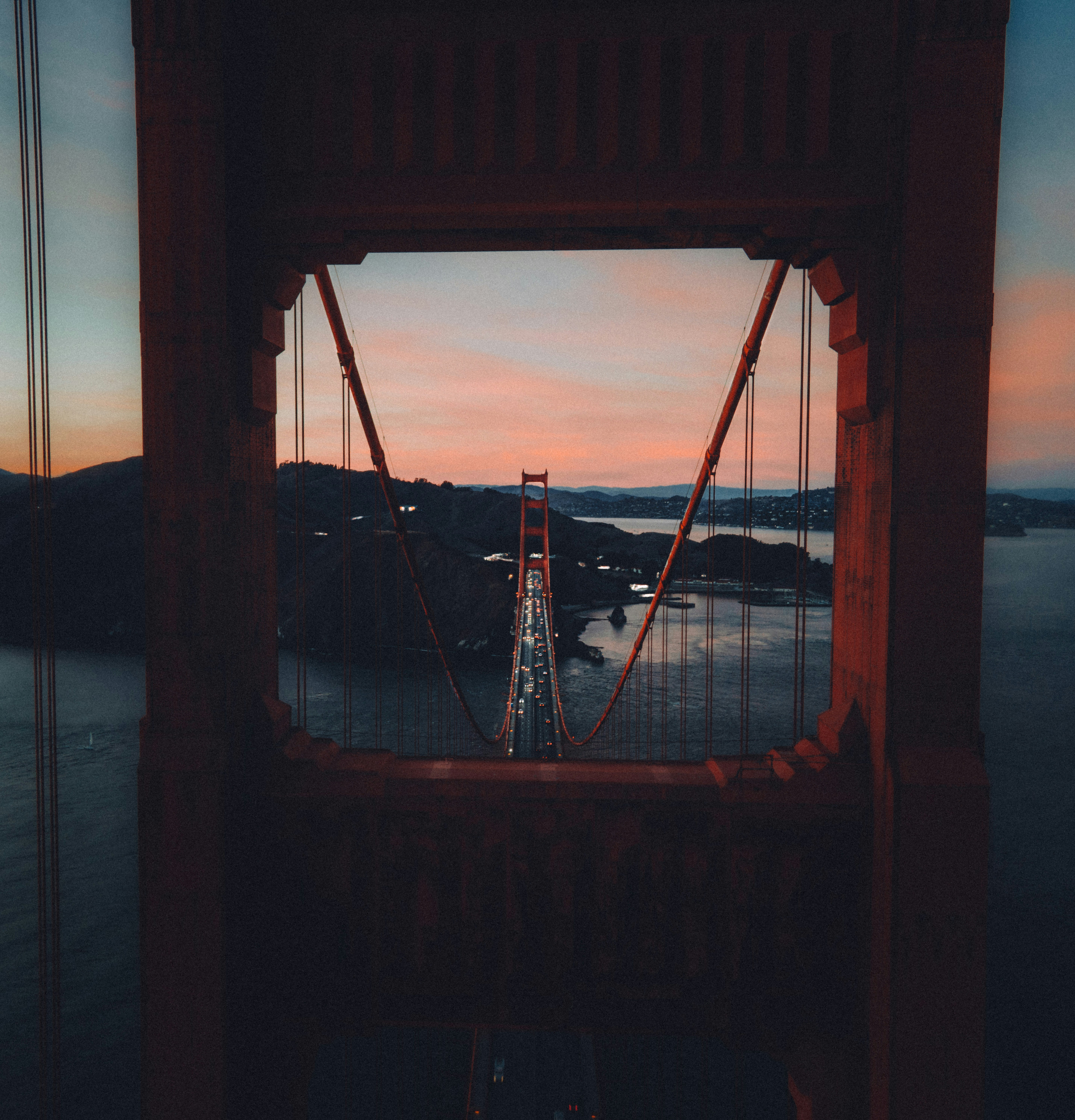 Golden gate bridge at sunset through its tower.