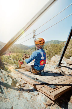 Man on zipline platform overlooking a valley