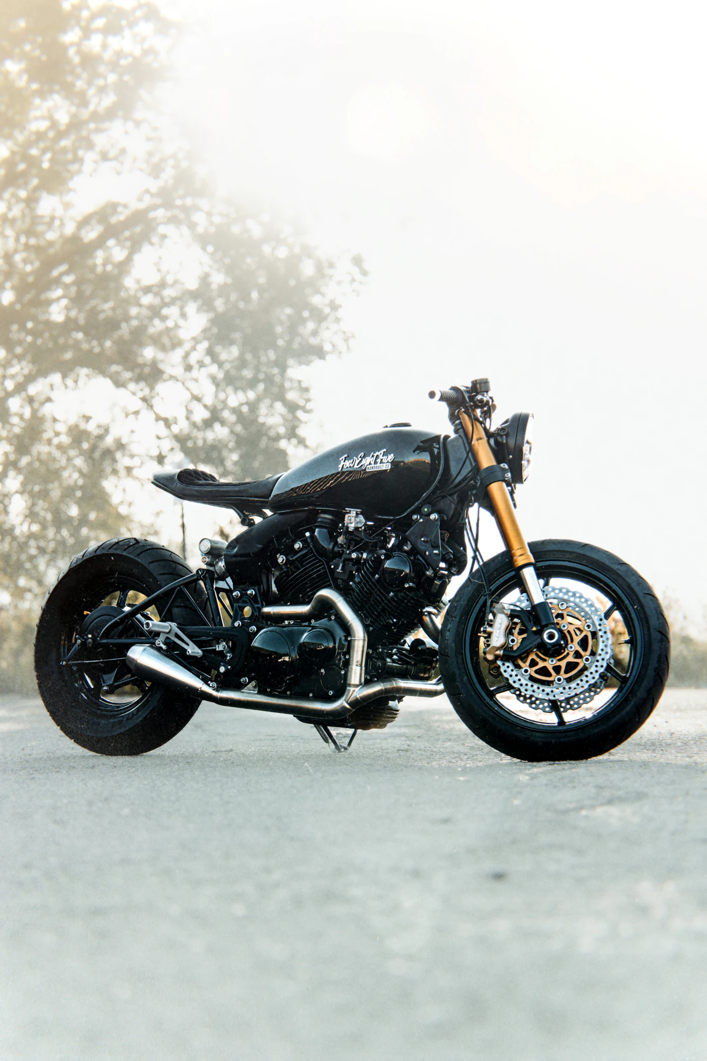 Black custom bobber motorcycle on a misty road, the kind of street bike Kings North Coast Customs tunes for the Oregon coast
