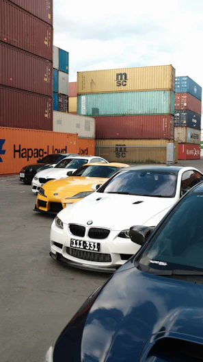Several cars parked near shipping containers