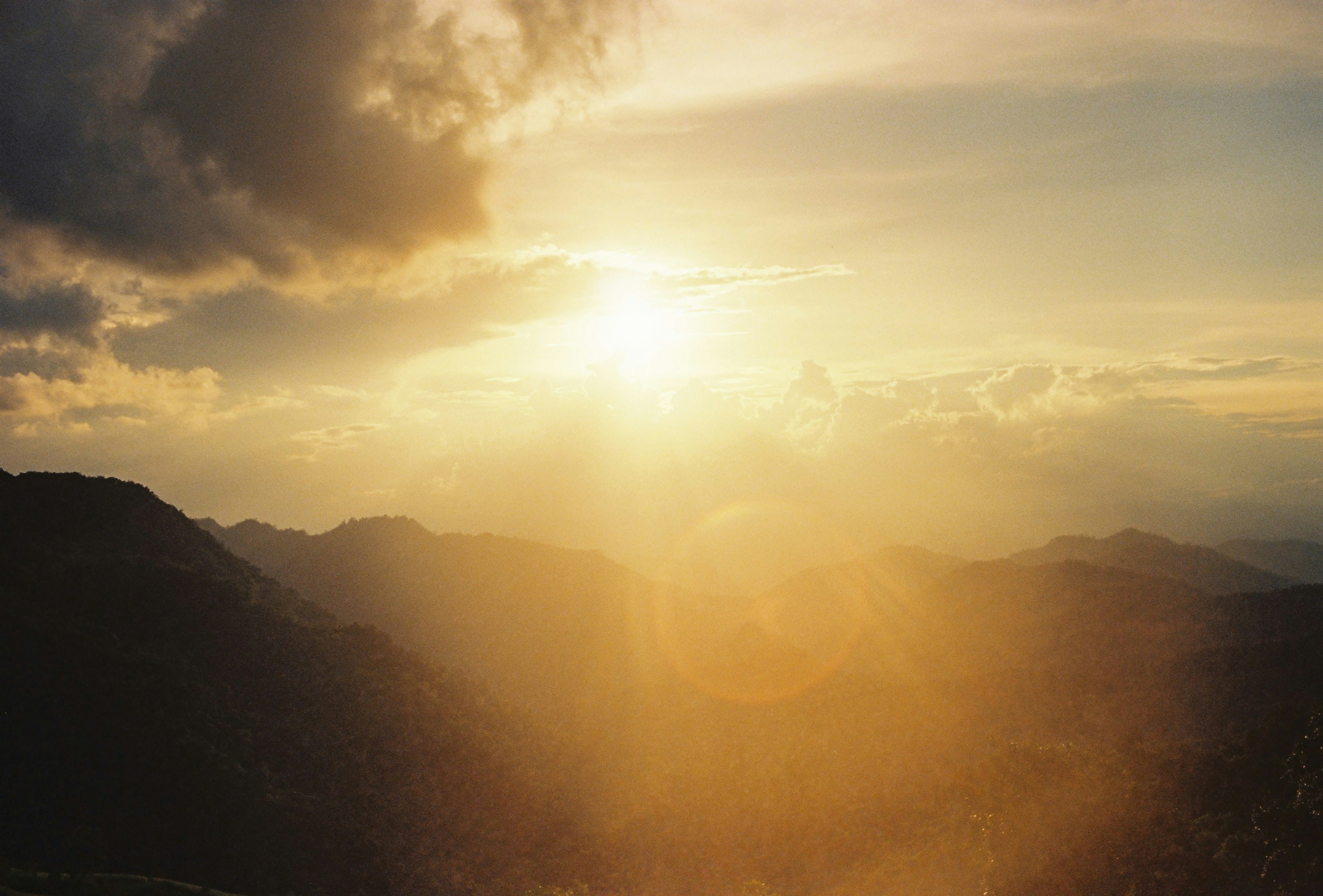 La luz del sol fluye a través de las nubes sobre las montañas.
