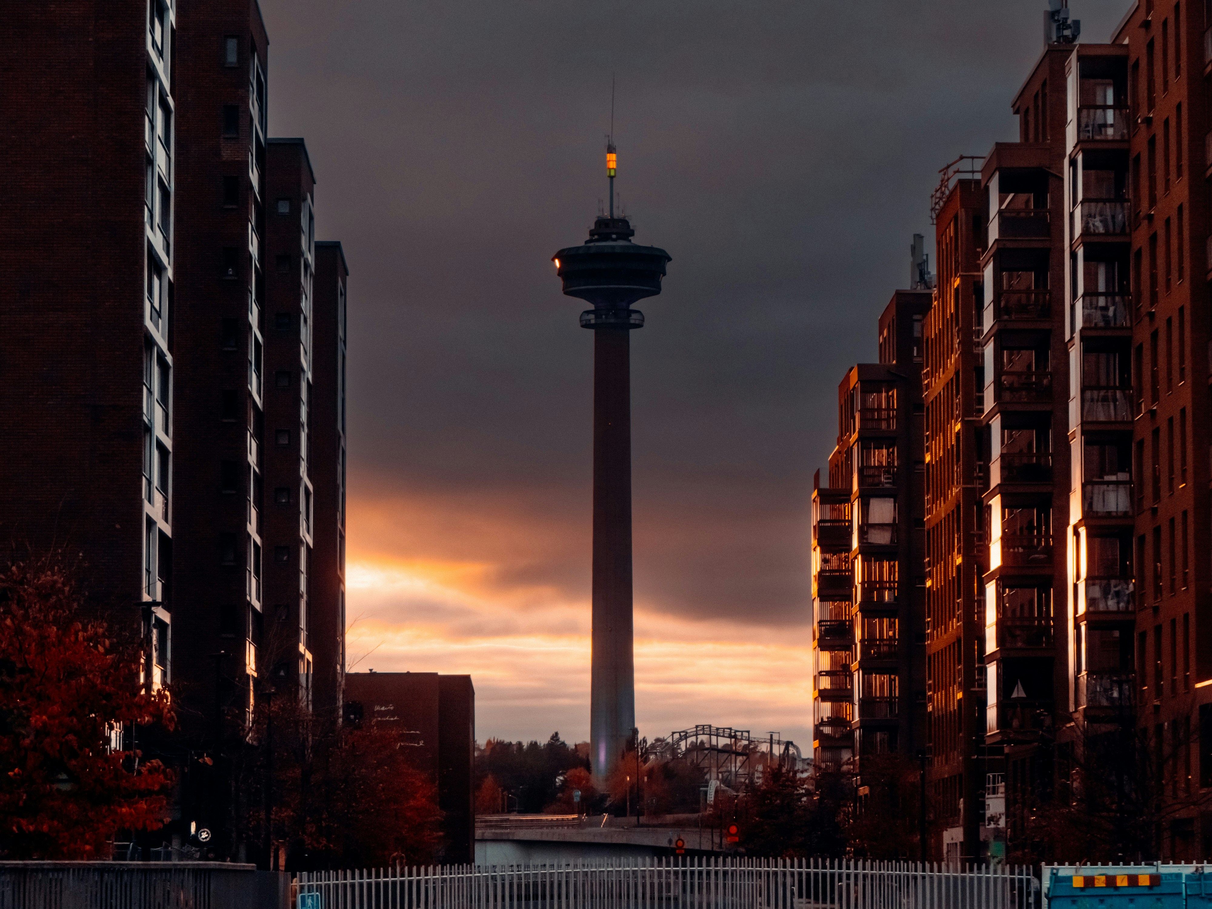 Tall observation tower between apartment buildings at sunset