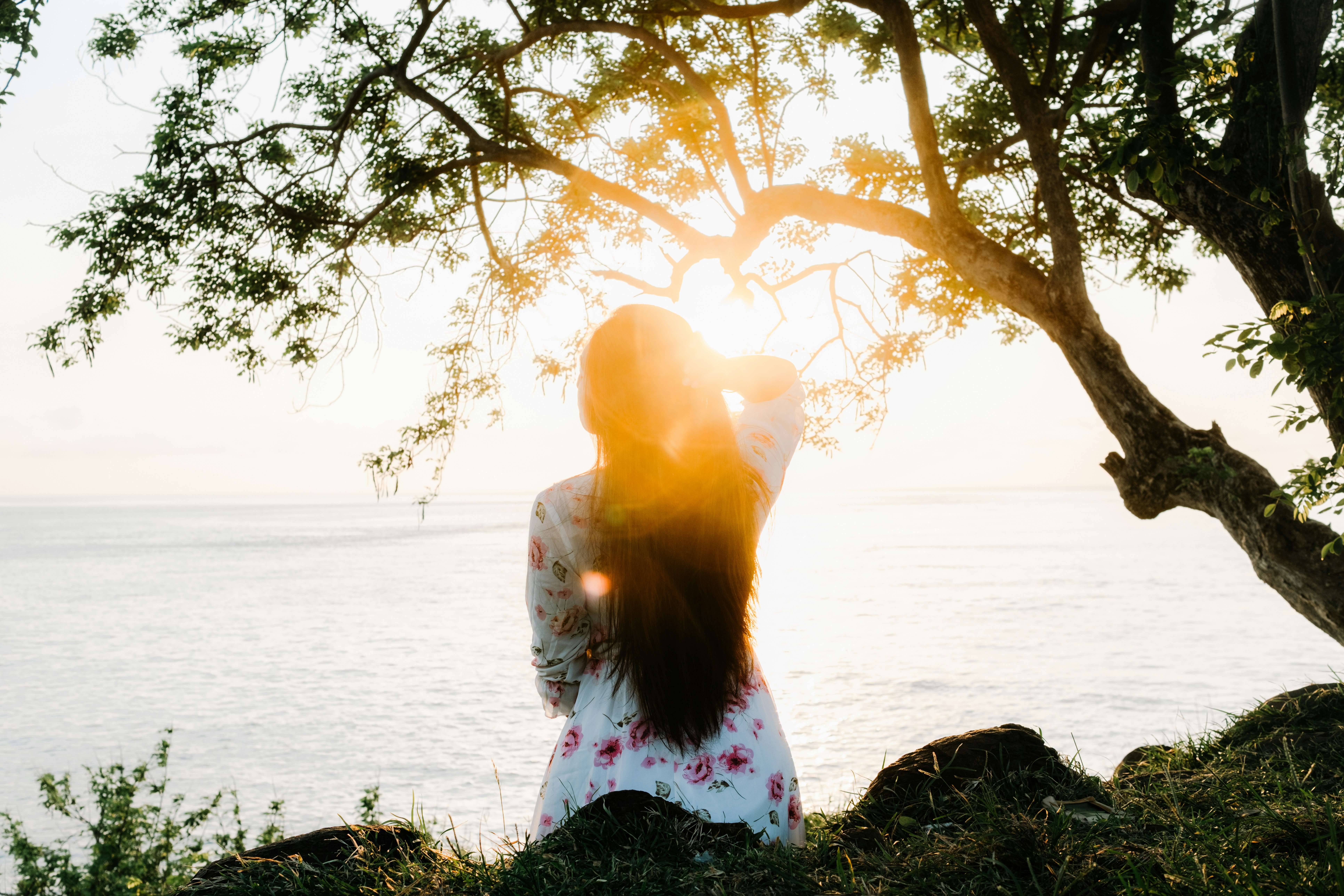 Woman in sunlight by ocean