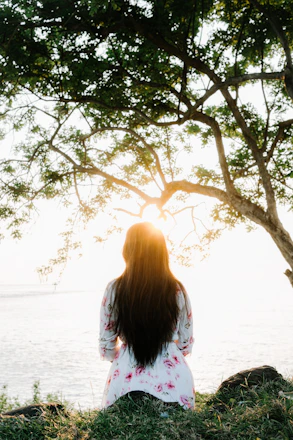 Woman sitting under a tree at sunset Seventh Sky Healing in USA