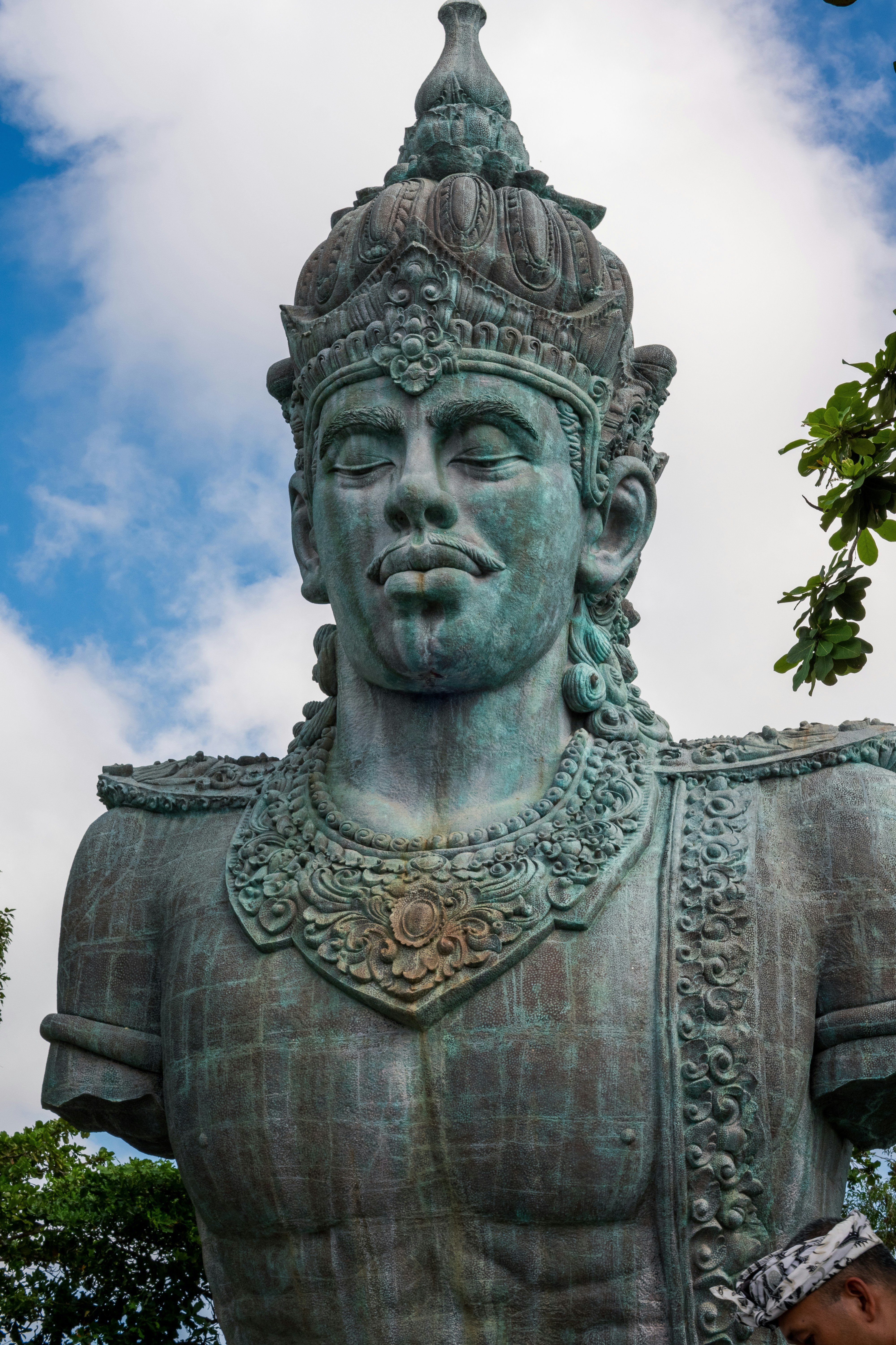 A large ancient statue with intricate details and a crown.