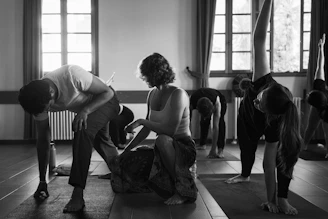Yoga instructor assisting student in class
