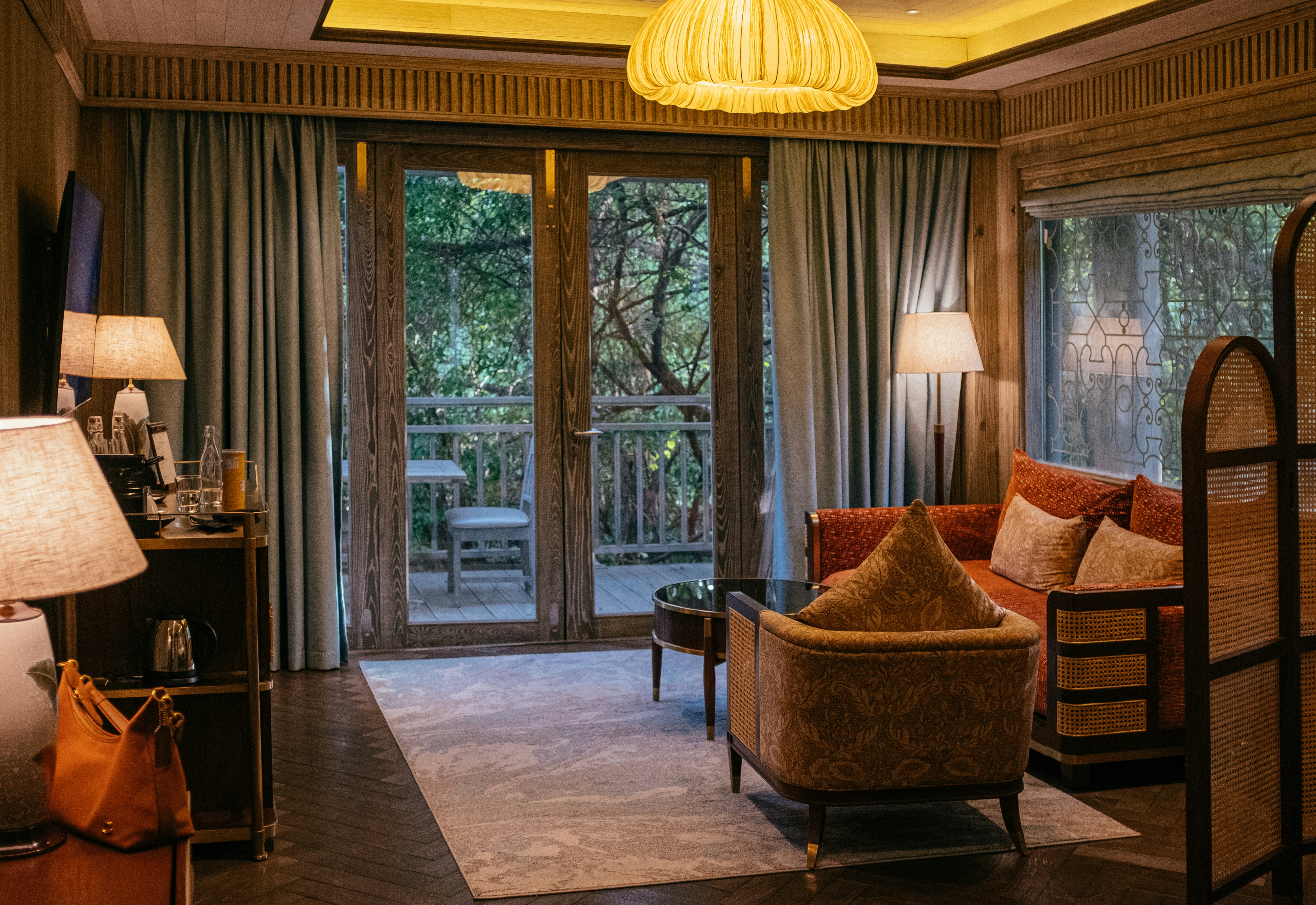 Luxurious hotel suite with balcony overlooking trees