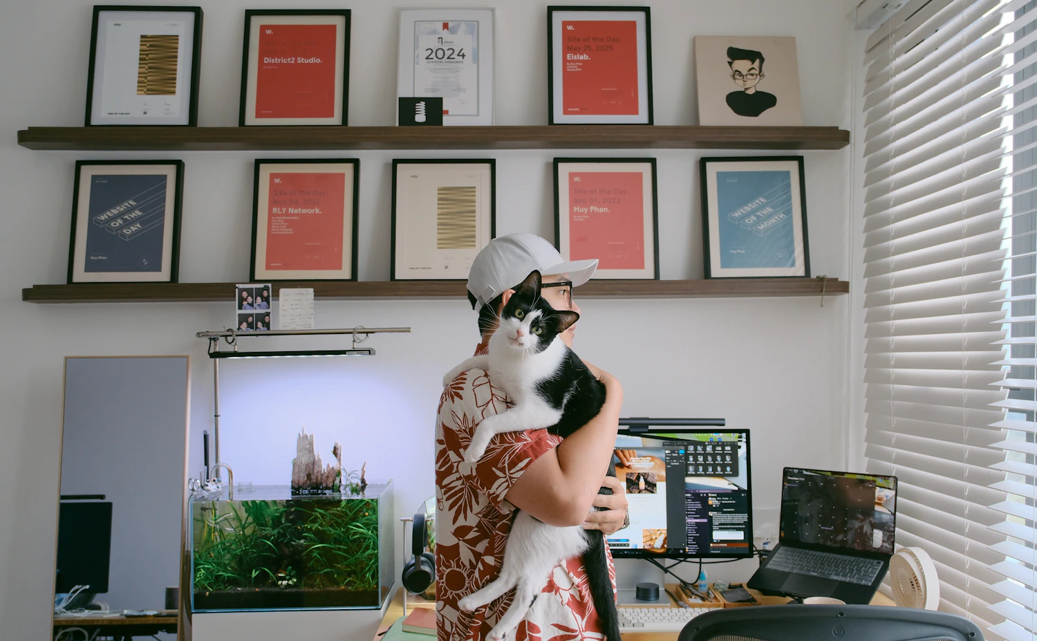 Pet owner holding a cat in a bright home workspace