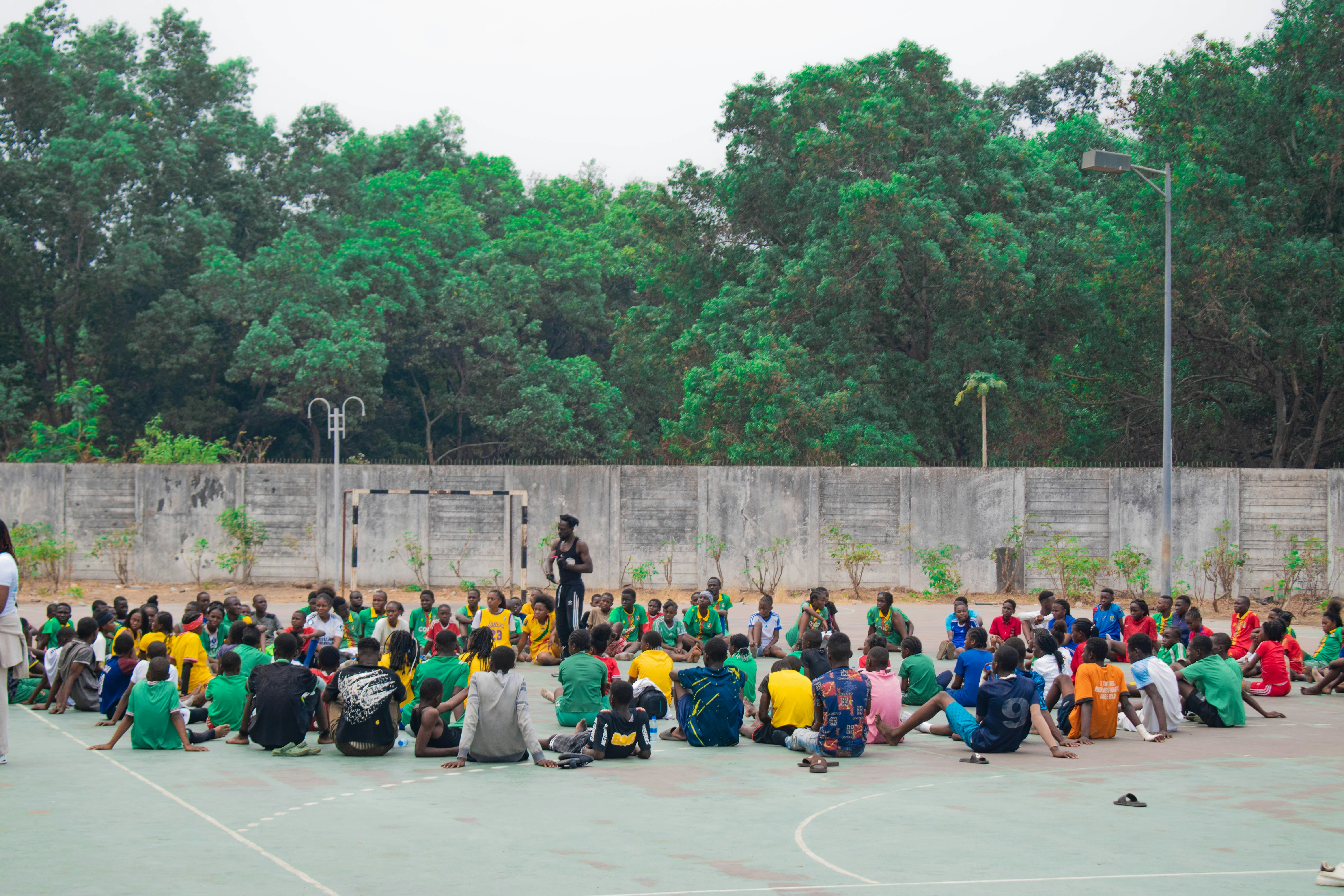 Group of people sitting in a circle outdoors.